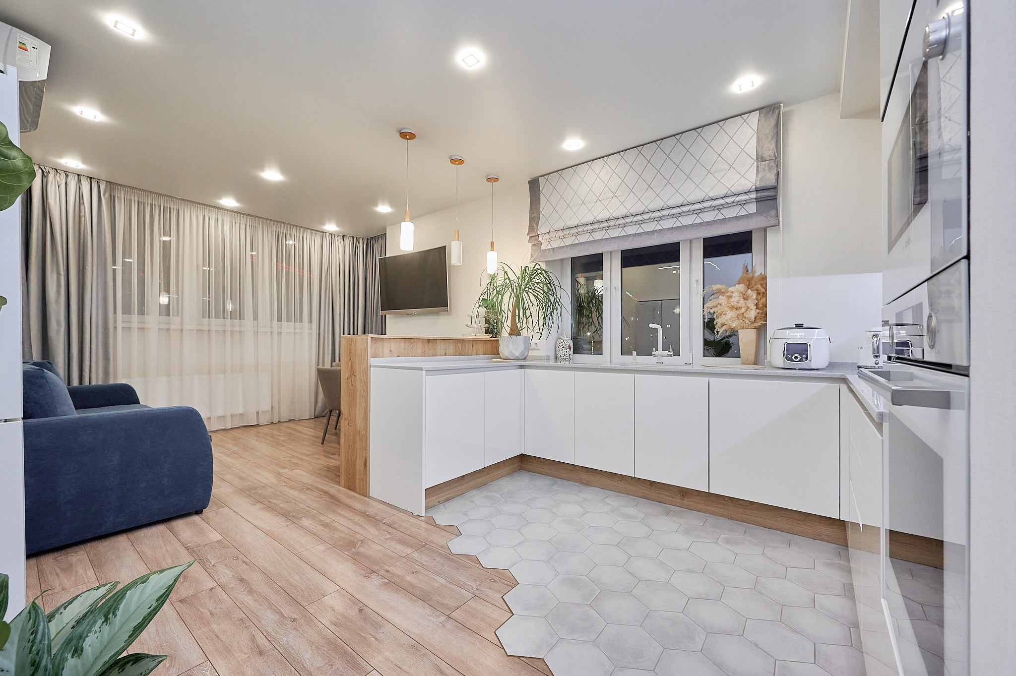 кухня белые шкафчики  синий диван  светлый ламинат 