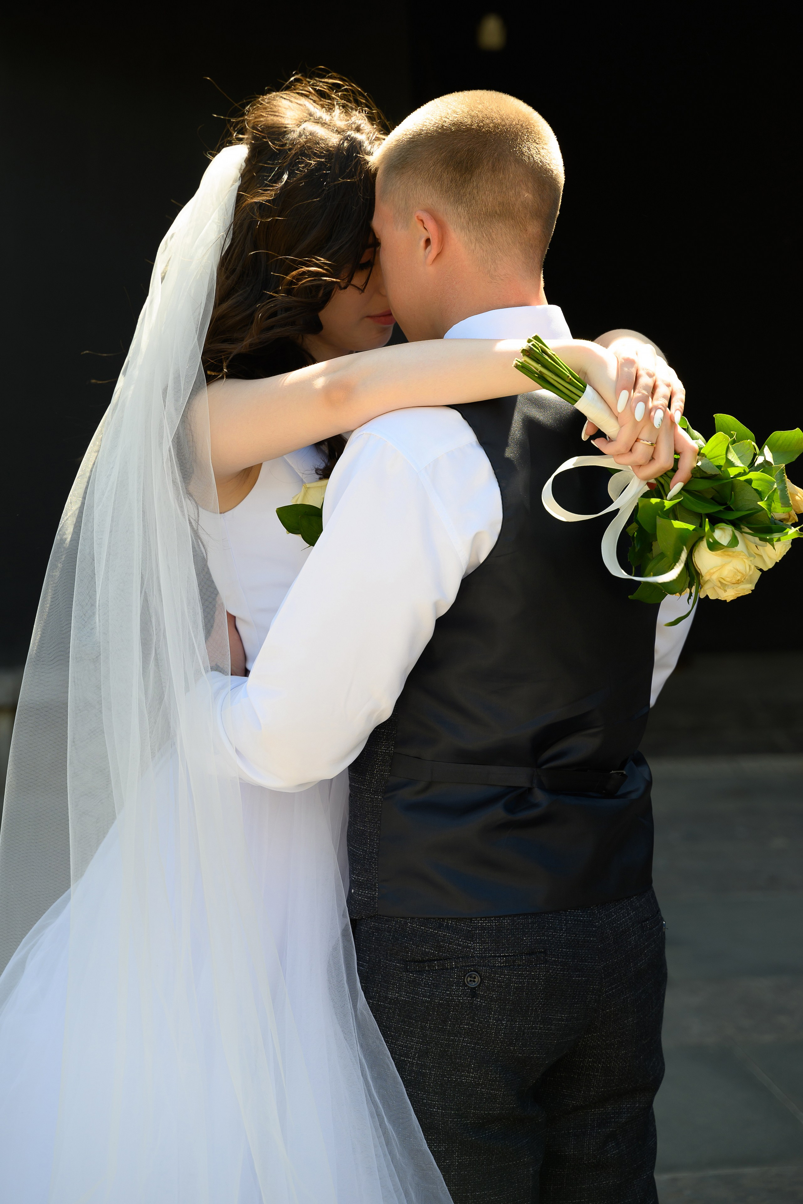 Жених обнимает невесту, светит контровое солнце, любовь, чувства, эмоции.