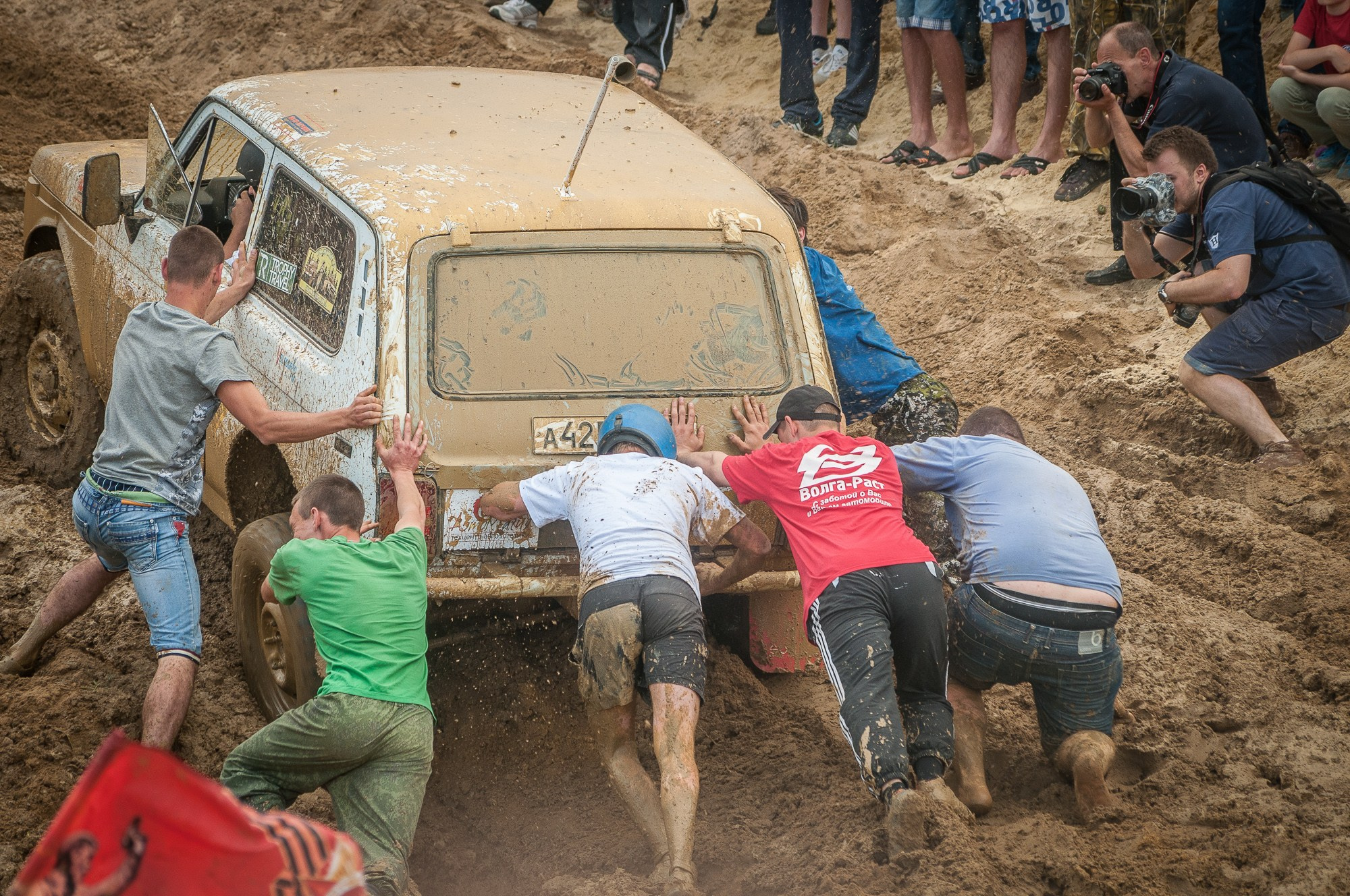 Зрители гонок "Генералы песчаных карьеров" помогают вытолкать застрявший автомобиль из грязи