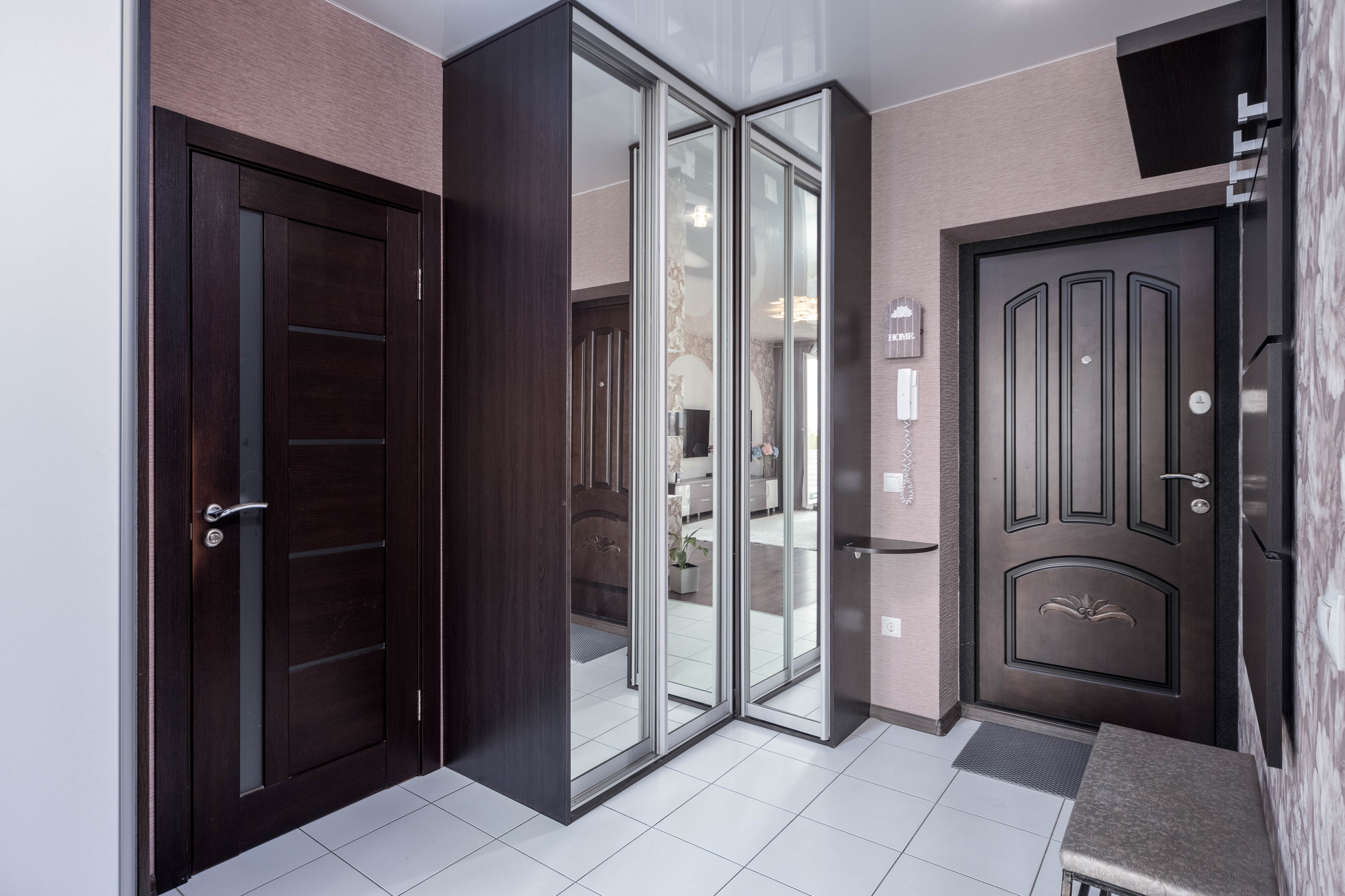 Прихожая - система хранения с зеркалом, проход в санузел и металлическая входная дверь в квартире-студии