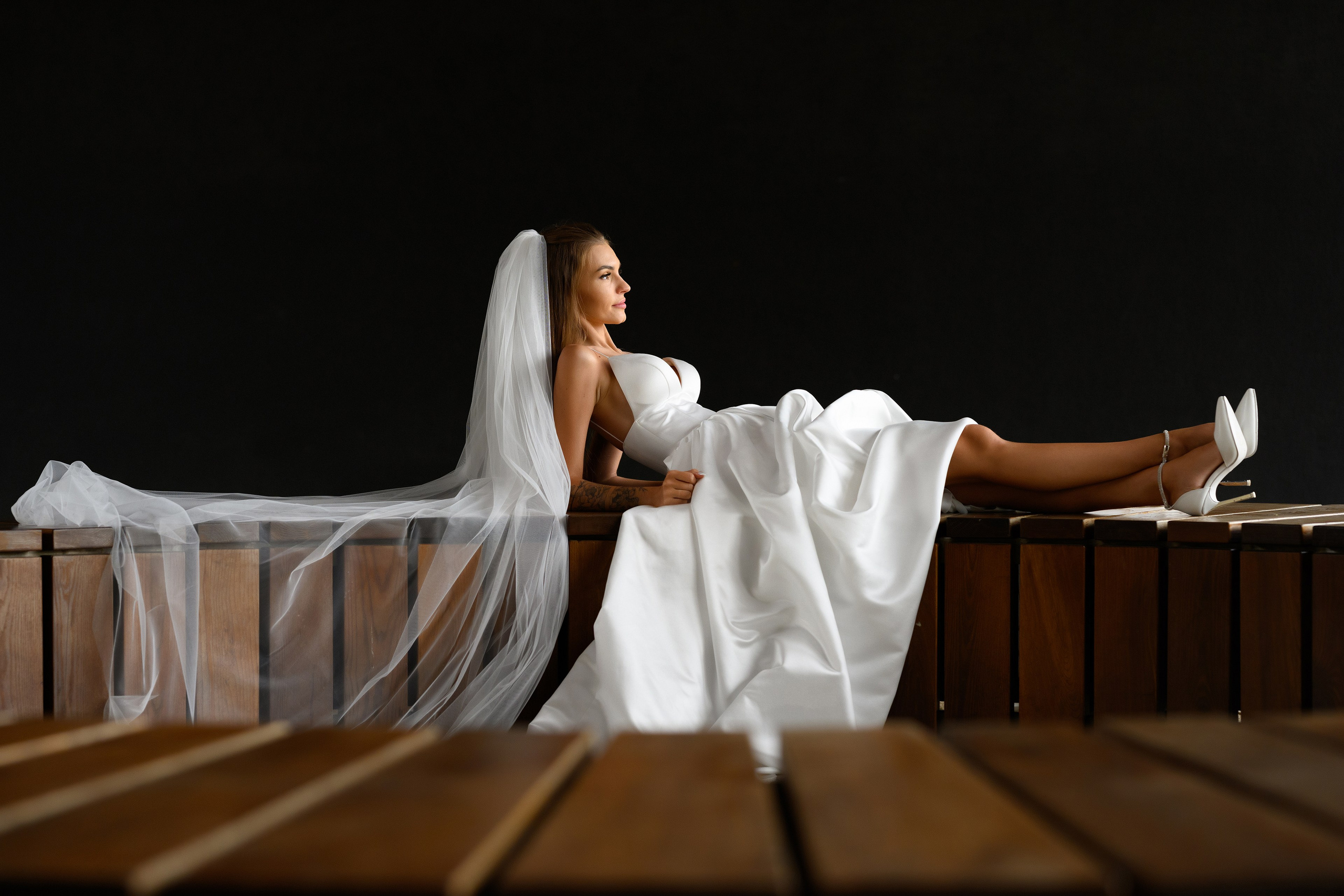 Прекрасное фото невесты в фате на скамейке.