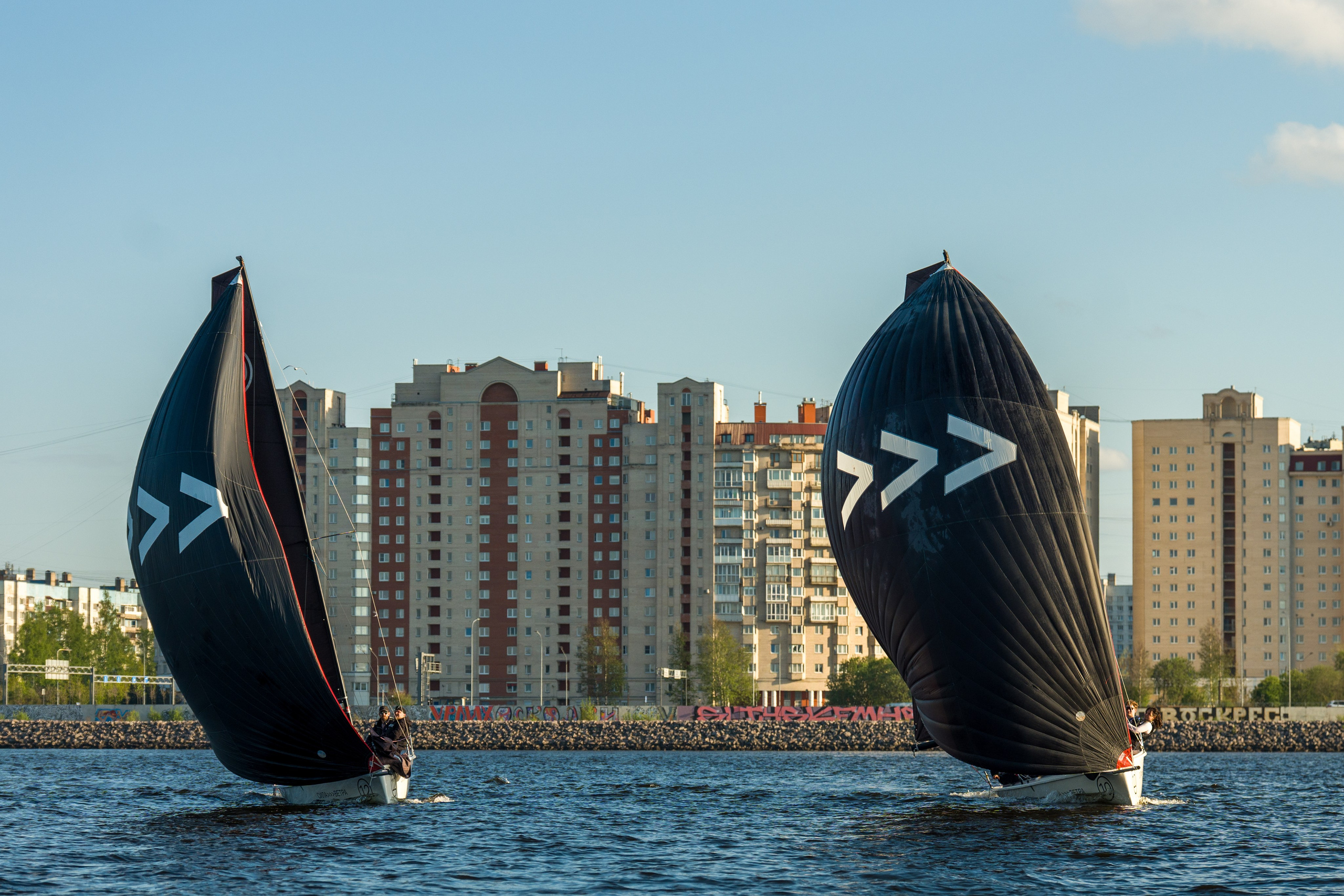 Two SV20s power along under black spinnakers on open water