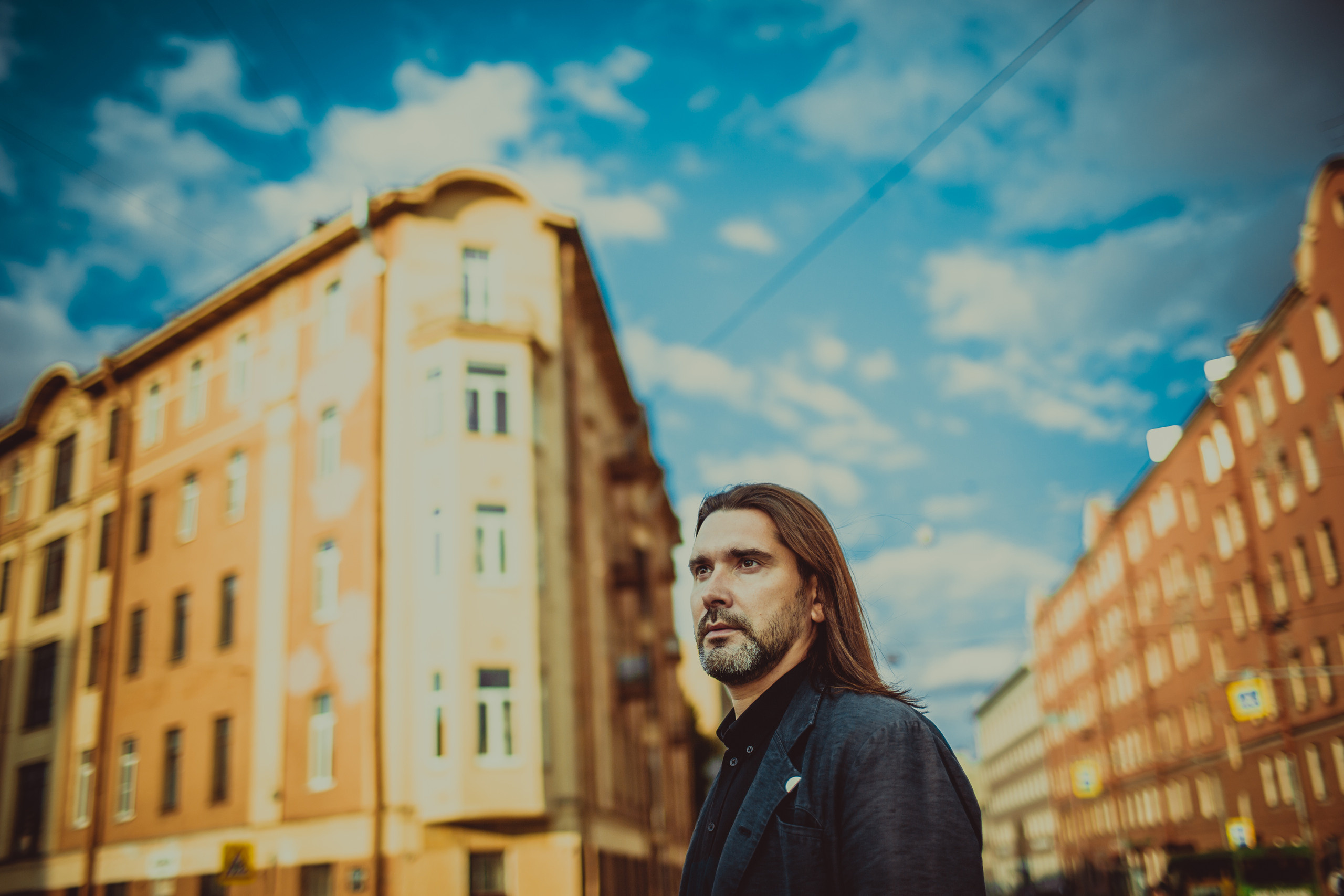 серьезный портрет на фоне домов и голубого неба