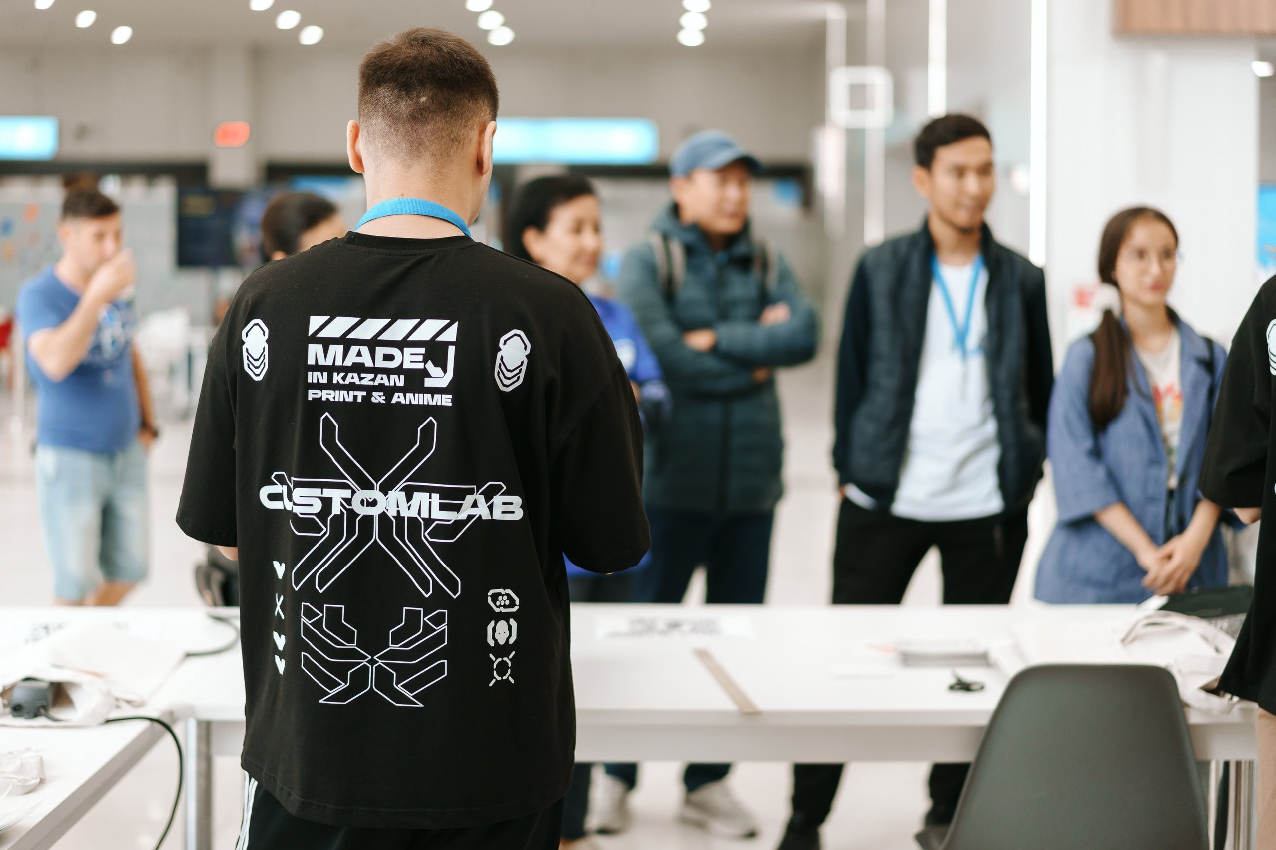 Сотрудник CustomLab в фирменной футболке на выставке Казань Экспо