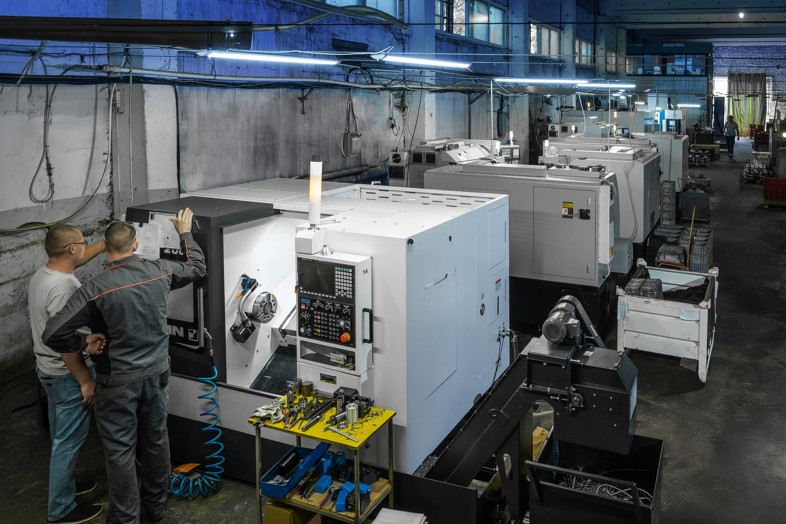 Оператор загружает программу и контролирует работу токарного станка с ЧПУ