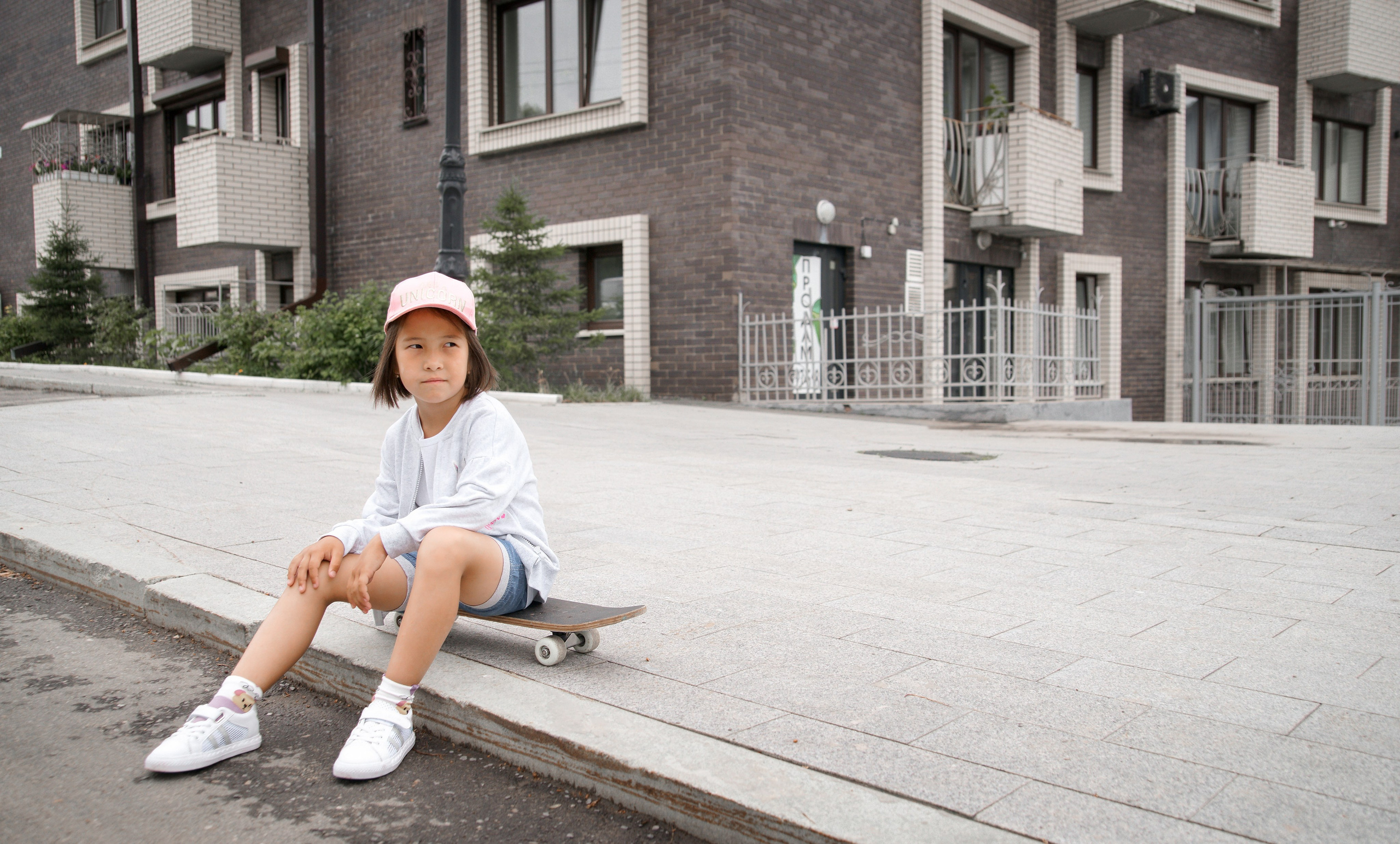 Детская фотосессия летом - девочка сидя в бейсболке