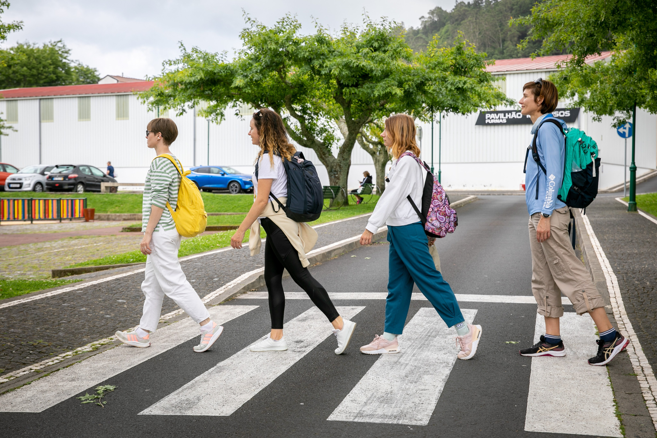 Women wander through the stunning landscapes of the Azores, surrounded by green hills, the ocean, and an open sky above