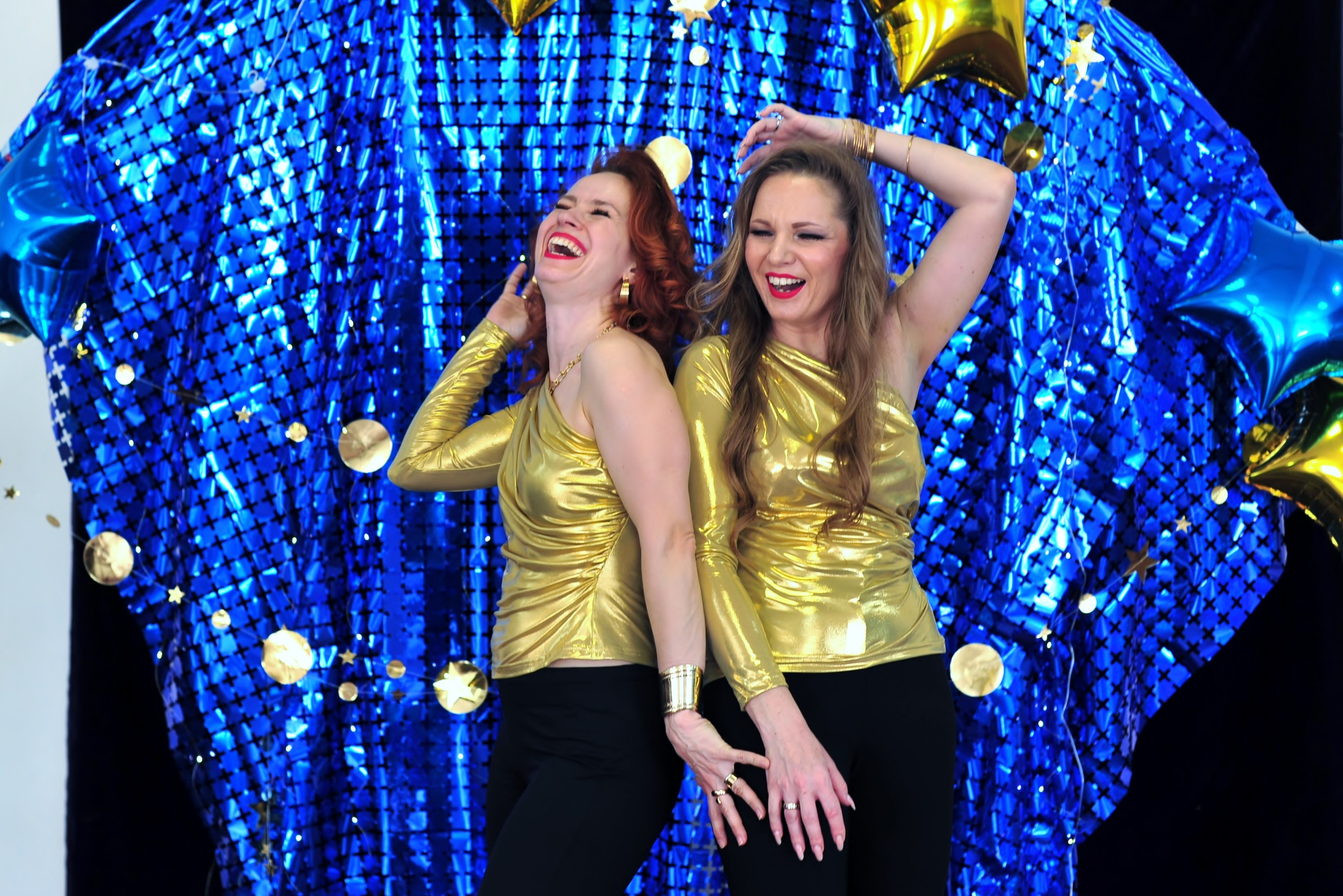 Девушки в золотых блузках у фотозоны