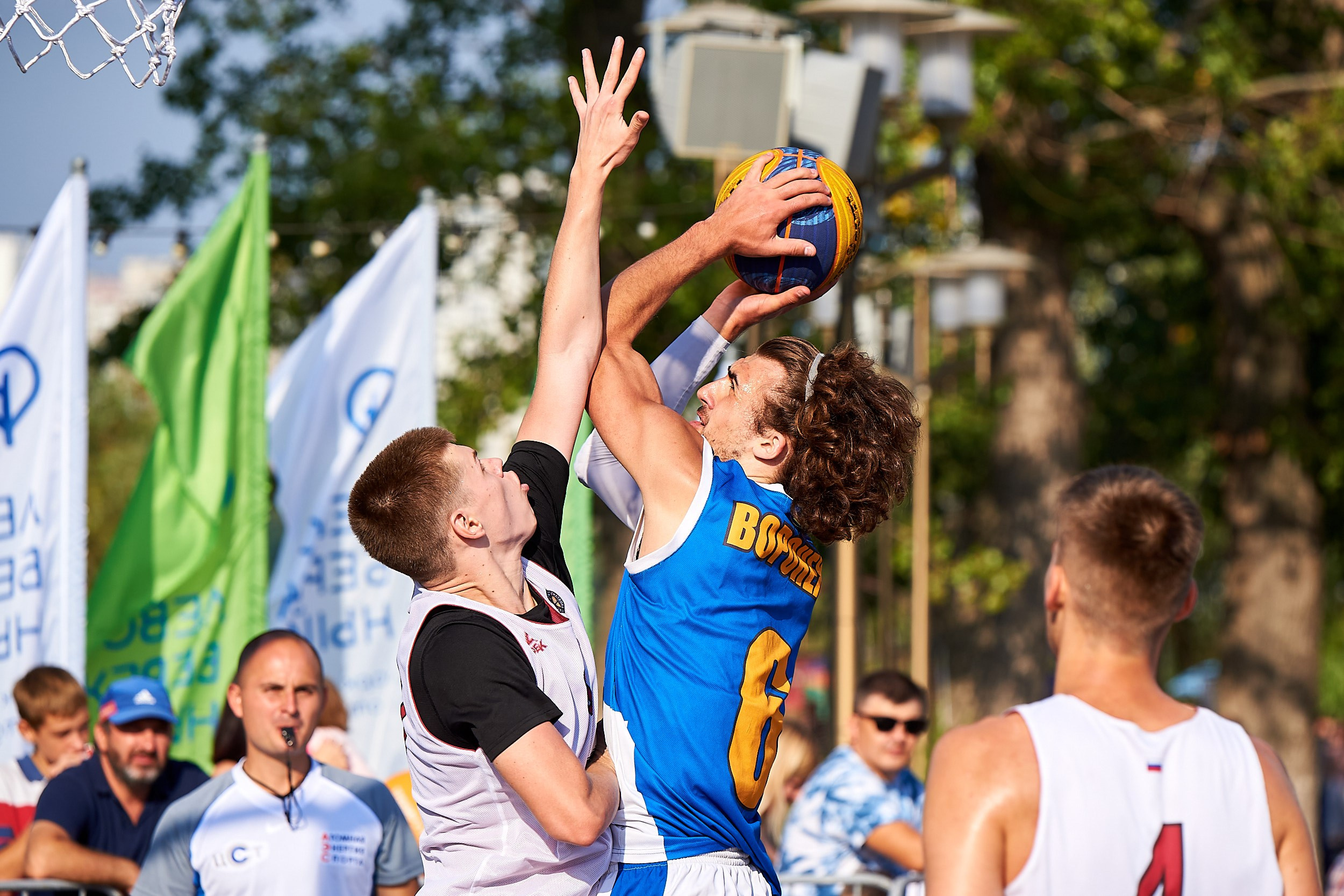 Репортажная съемка баскетбольного матча: игрок пытается забросить мяч в кольцо