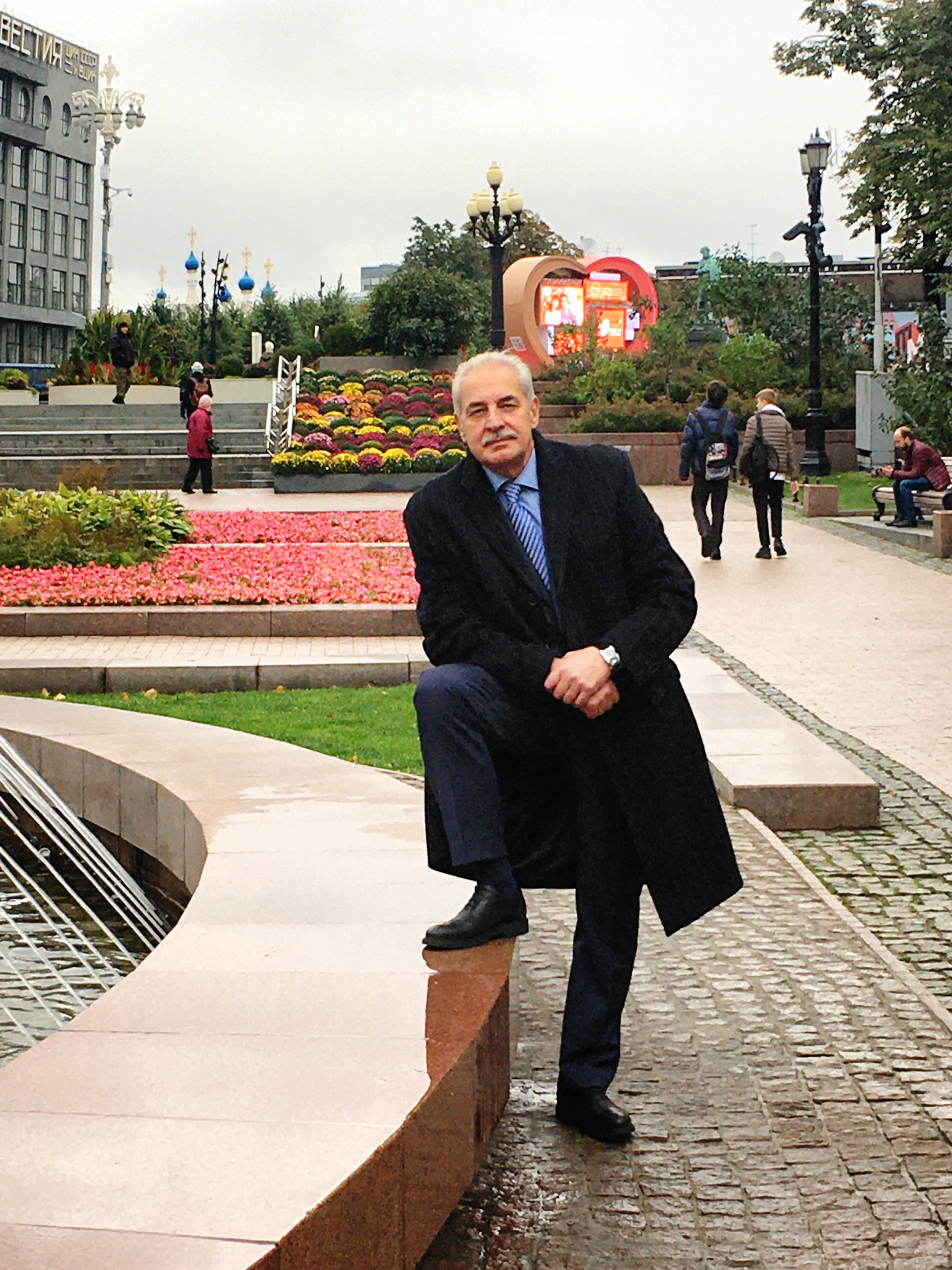 Адвокат Восканян Микита Михайлович, в сером, строгом костюме и чёрном пальто на пушкинской площади в сквере у кинотеатра Пушкинский.