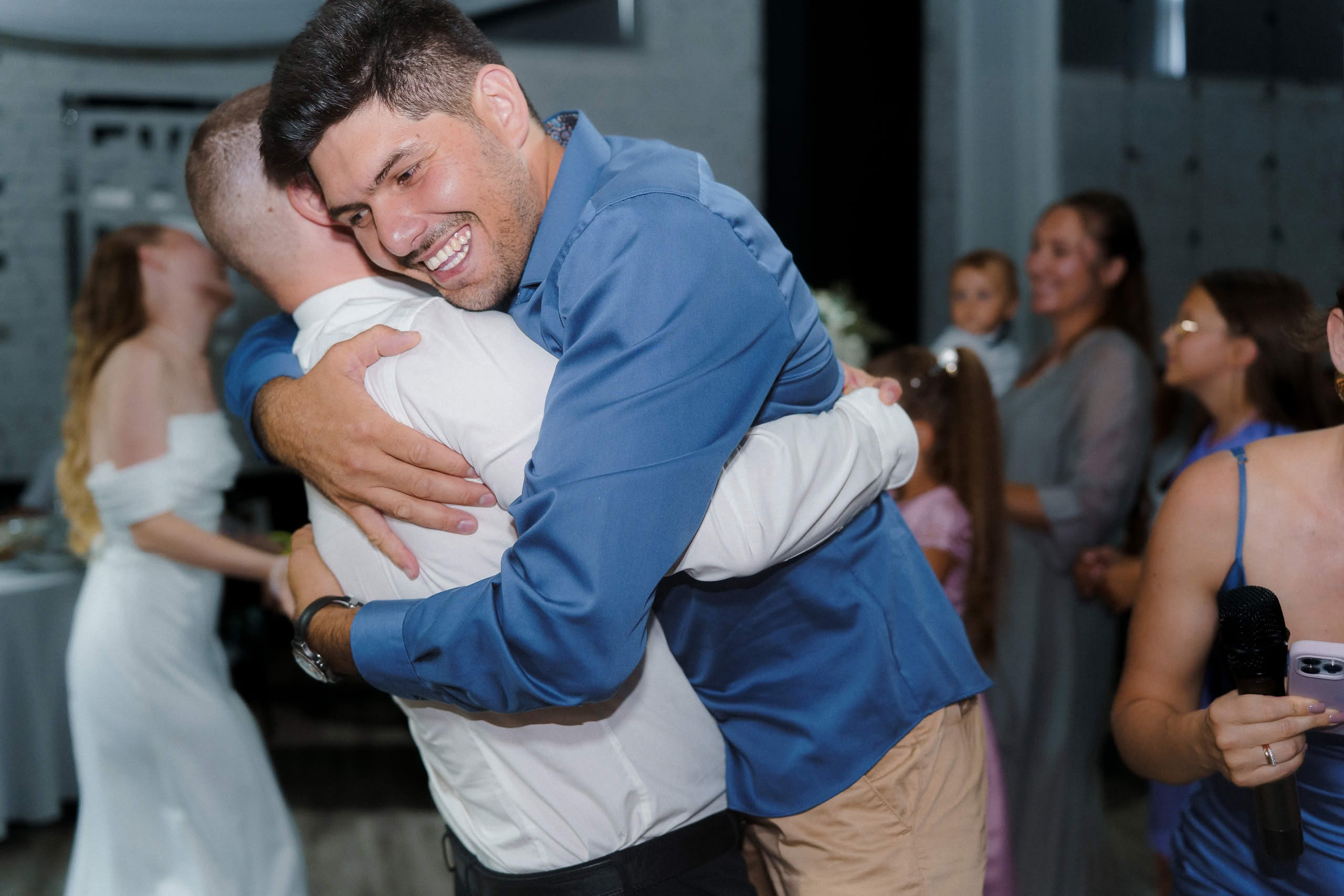 Друзья обнимаются на свадебном вечере Анны и Ильи