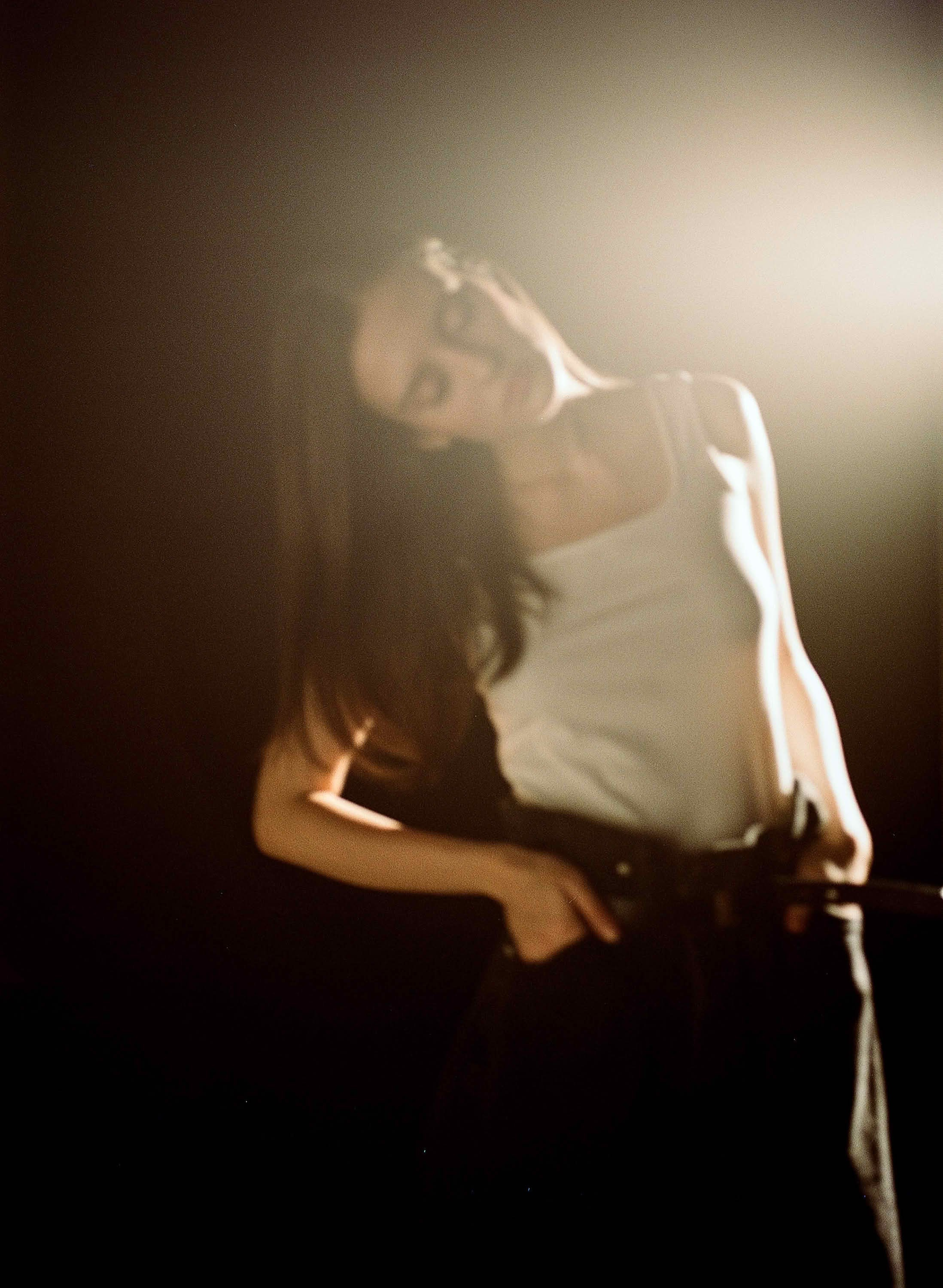 Фотосессия на плёнку СПб — девушка в боковом луче света, силуэт на тёмном фоне, кинематографический кадр