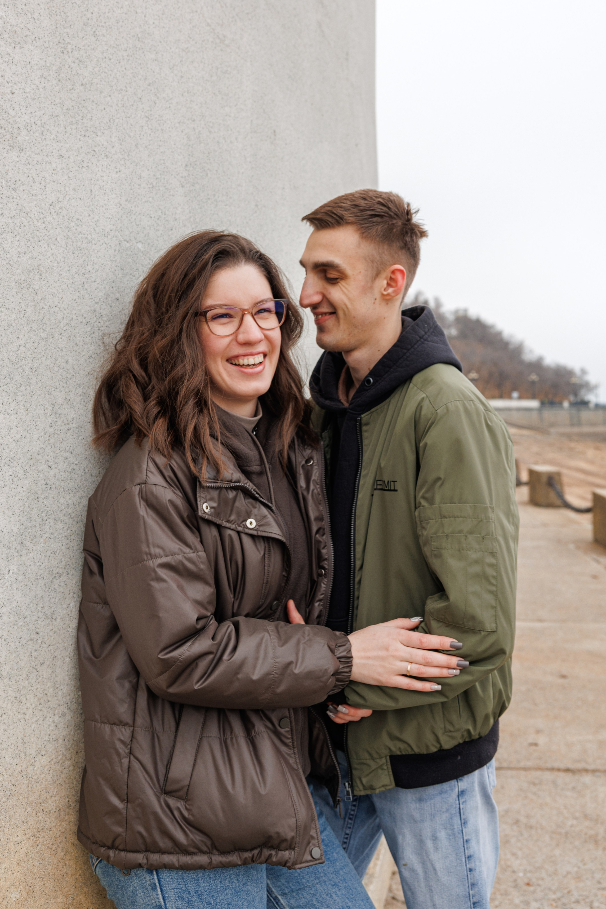 Живая фотосессия Love Story в Хабаровске: смеющаяся пара на прогулке по набережной Амура. Искренние эмоции и профессиональная уличная съемка
