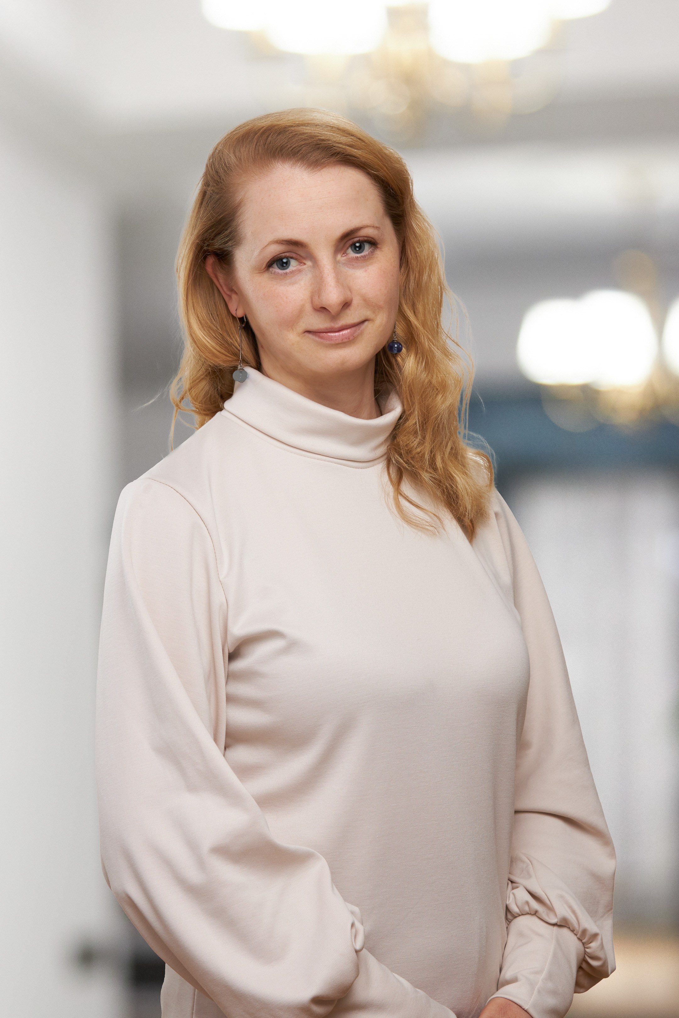 Business portrait of a young female doctor against a blurred interior background - photographer Andrey Dunin
