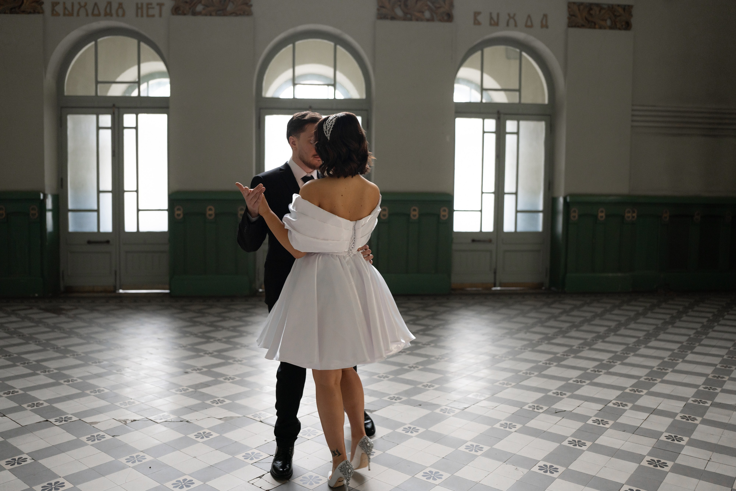 Жених с невестой танцуют в зале Витебского вокзала на свадебной фотосессии