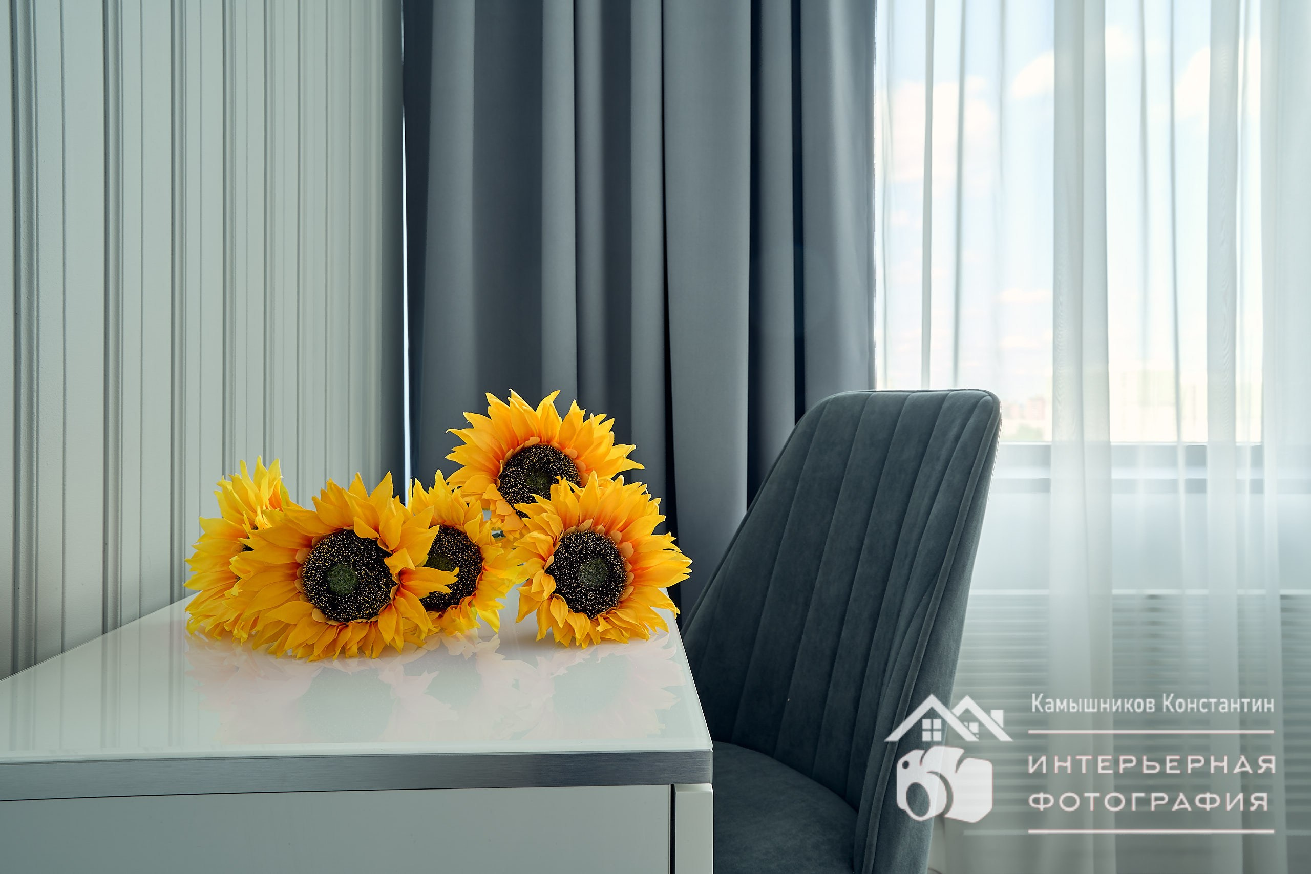 Интерьерное фото с подсолнухами на рабочем столе крупным планом в апартаментах бизнес-класса в Москве
