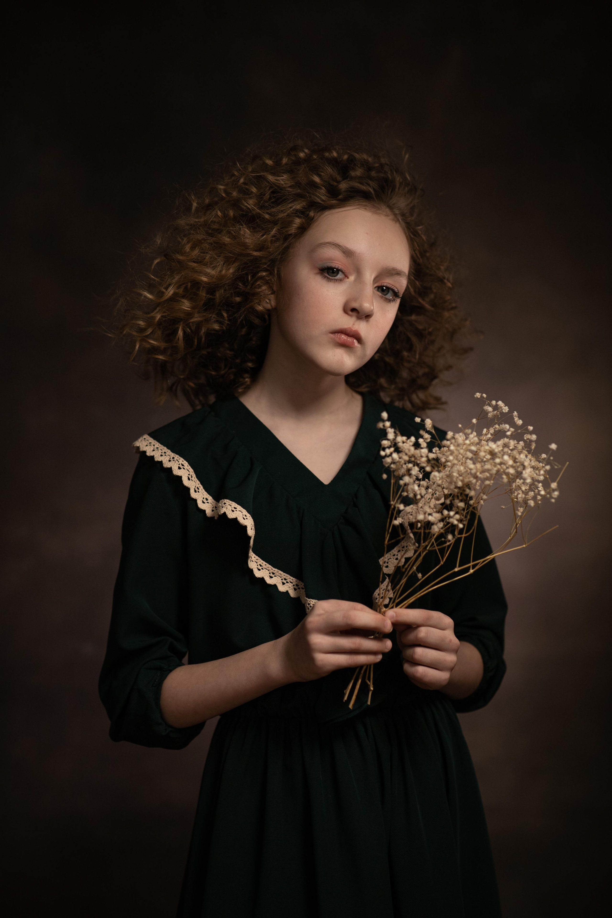 кудрявая юная девушка с задумчивым взглядом