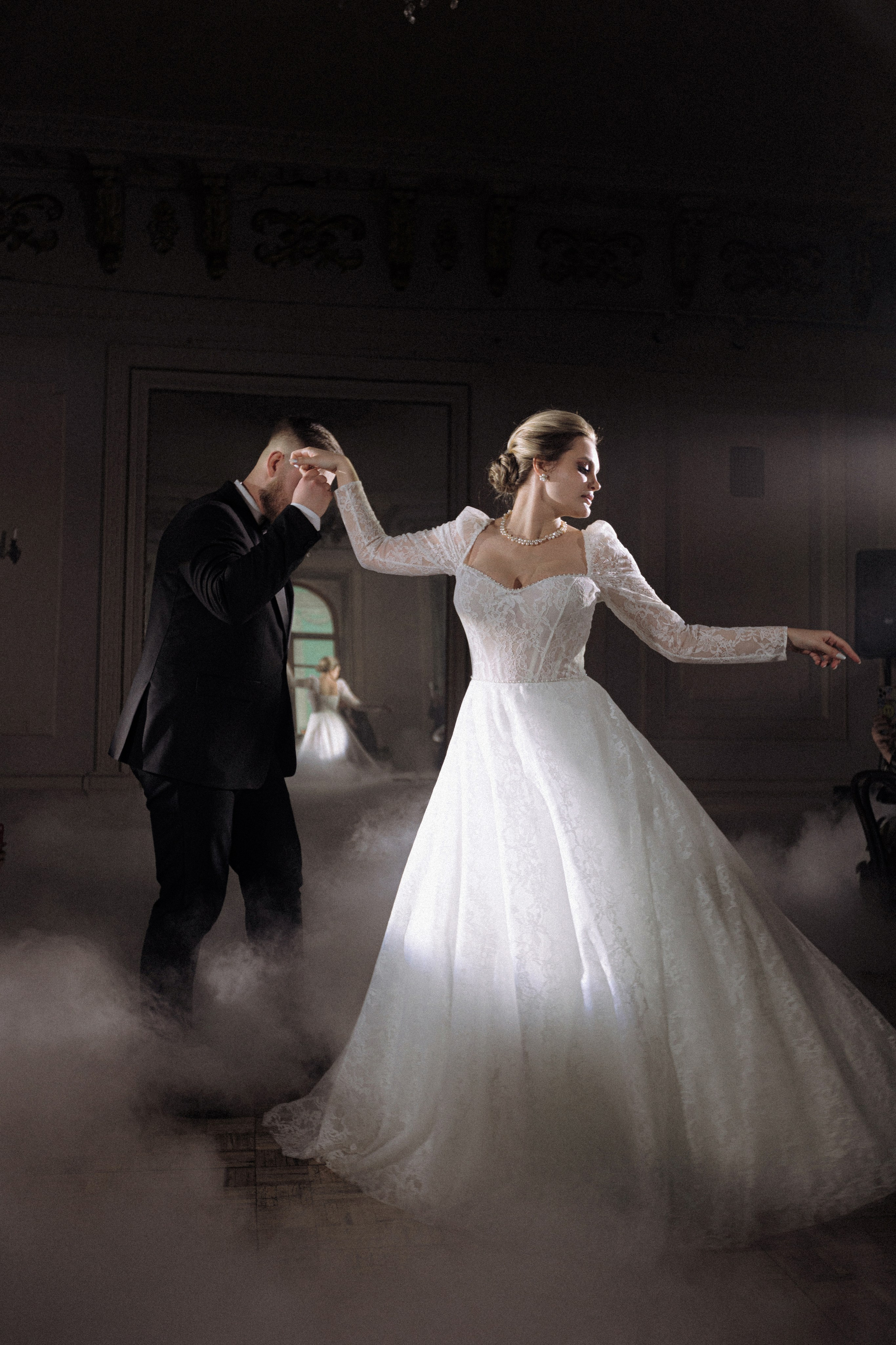 Невеста и жених танцуют первый танец под светом свечей