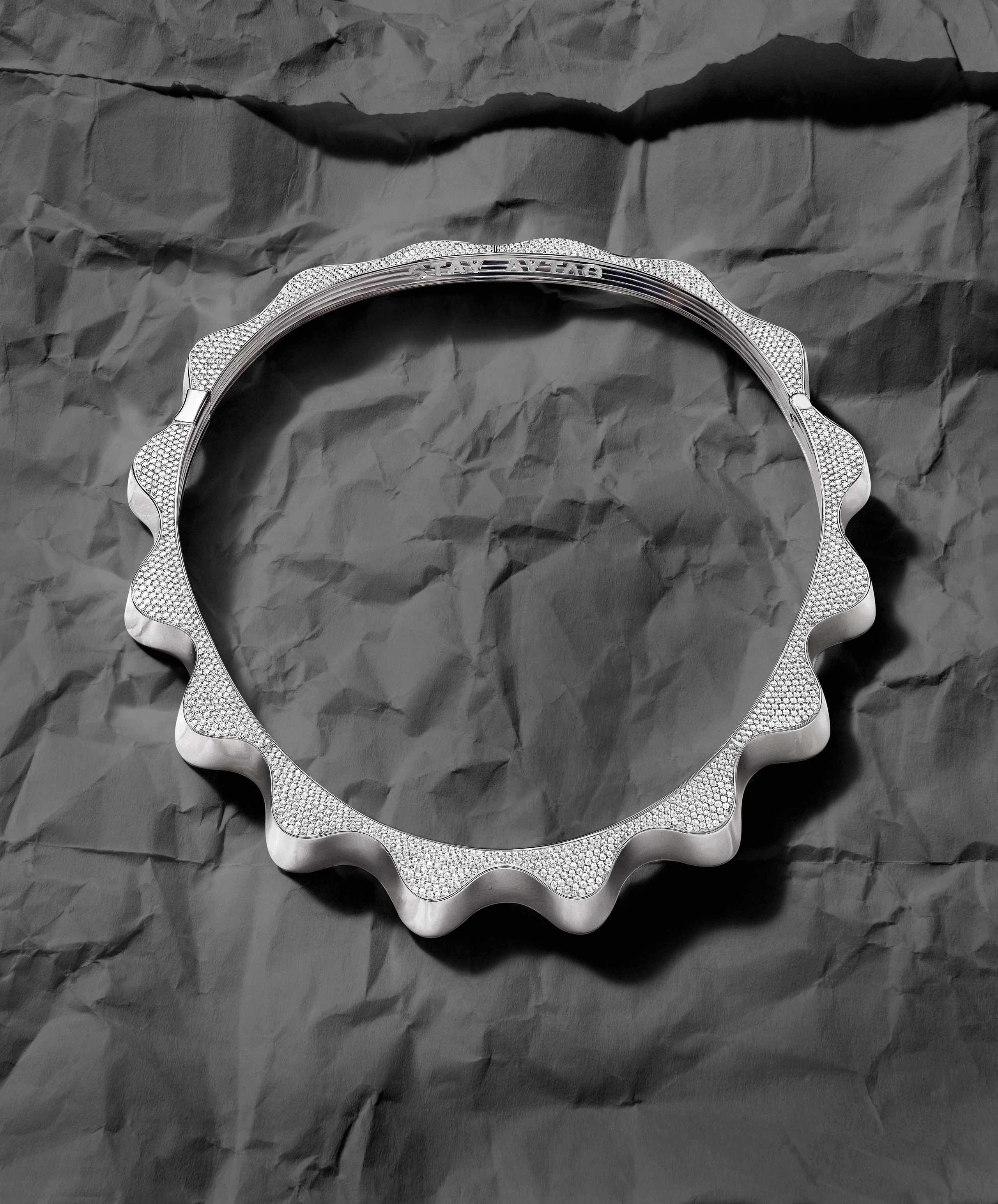 Стильная съемка ювелирных украшений, колье, на фоне мятой бумаги