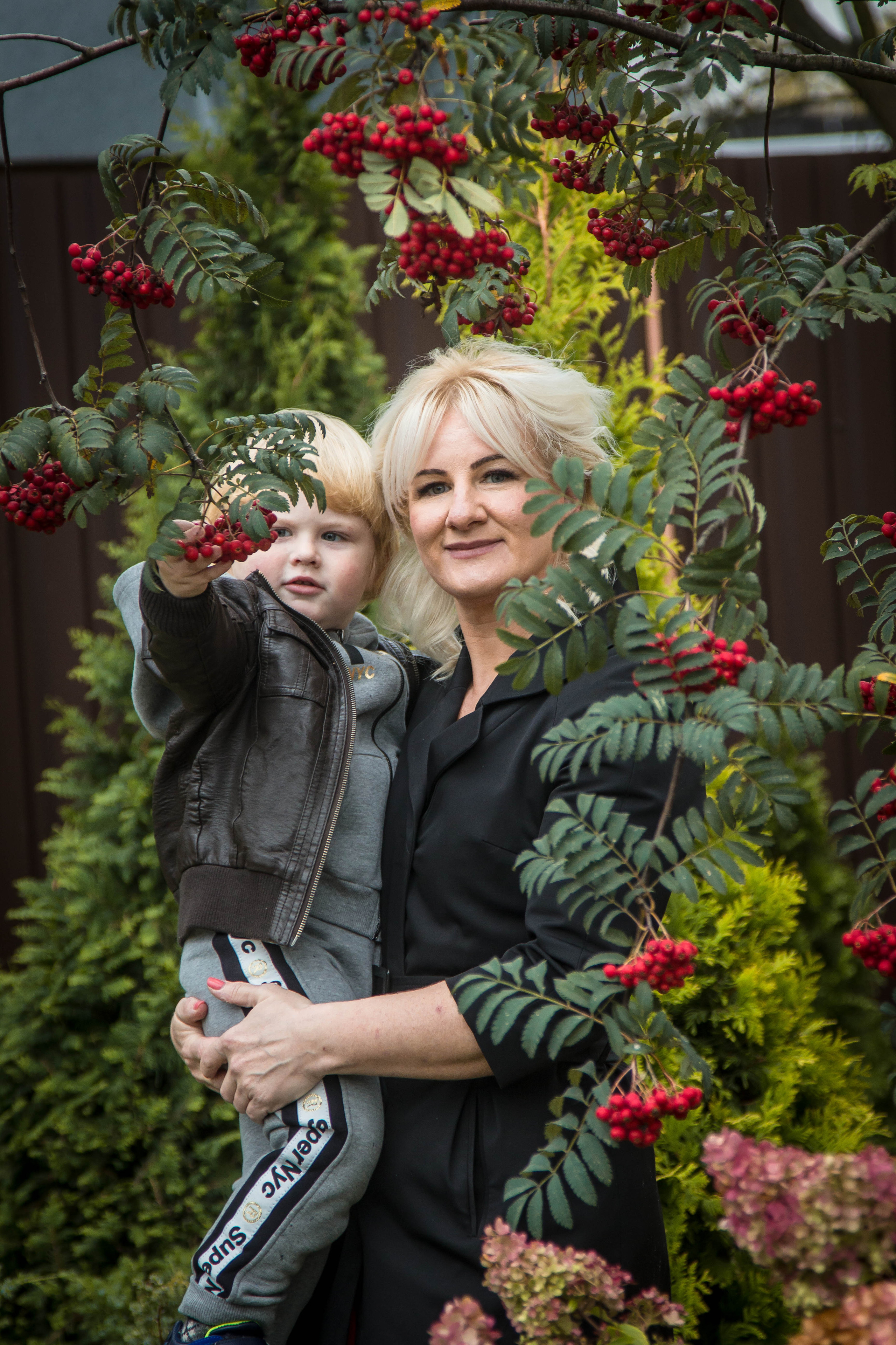 Мама с ребенком позируют перед фотографом в осенний день.