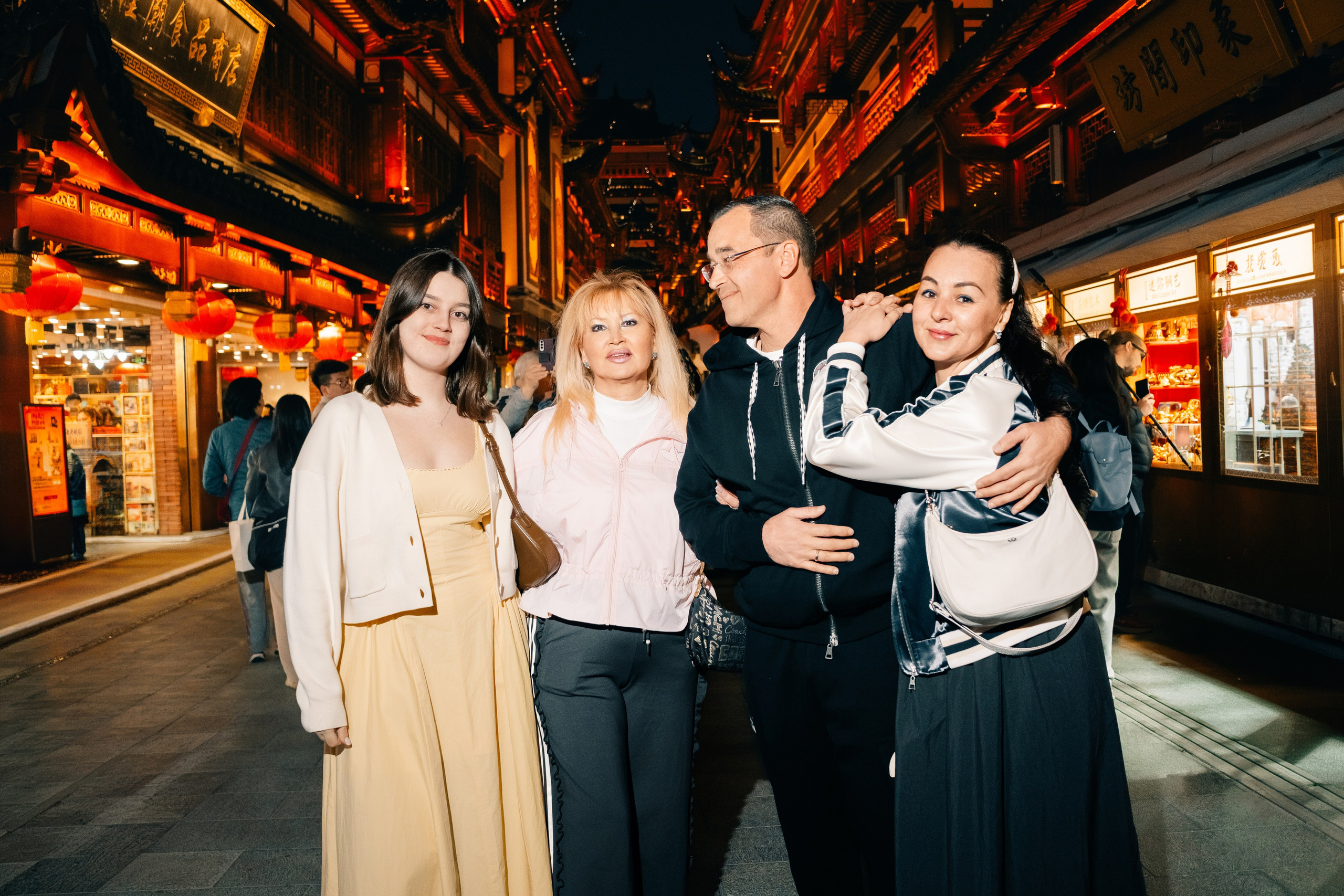 Family in front of bright lanterns at Yuyuan Bazaar in the evening in Shanghai, by a photographer in Shanghai.