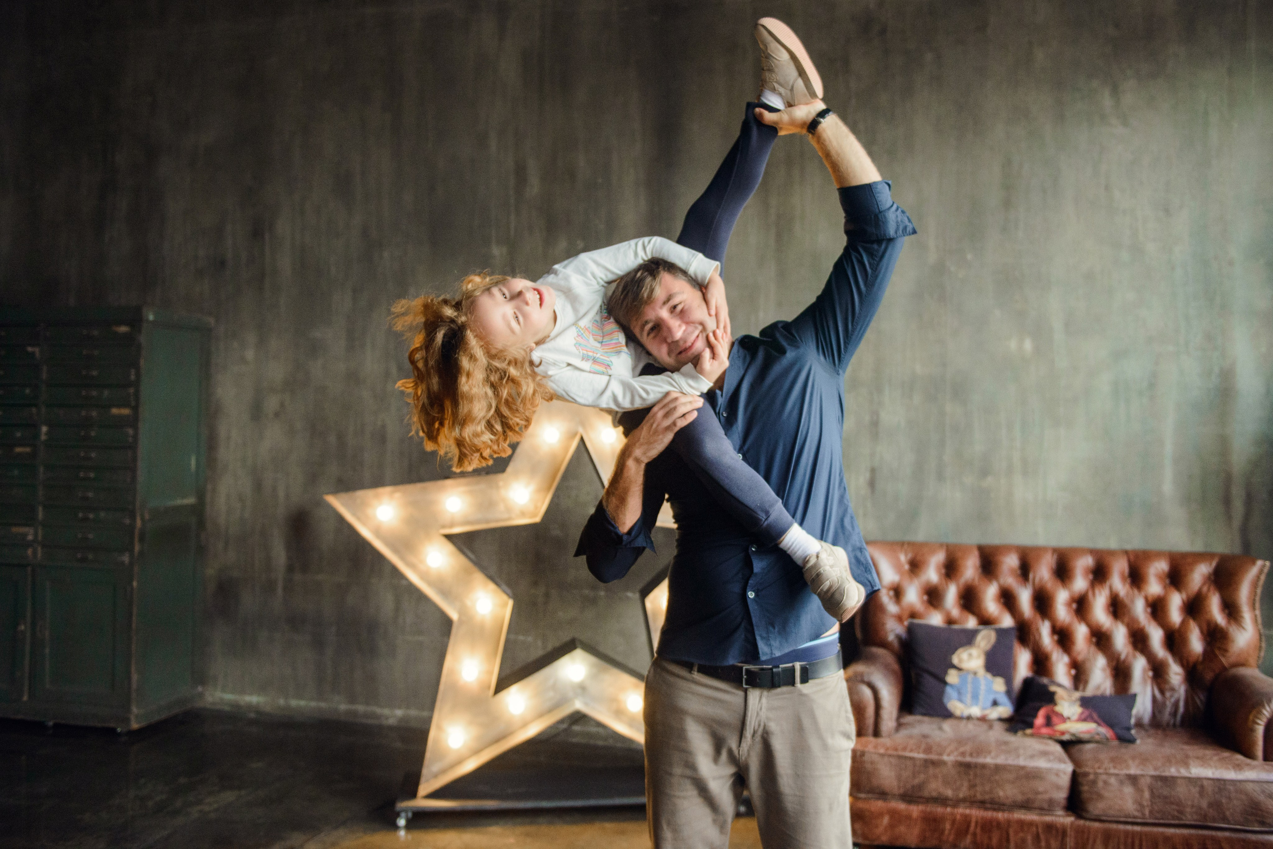 dad and daughter in a dark photo studio