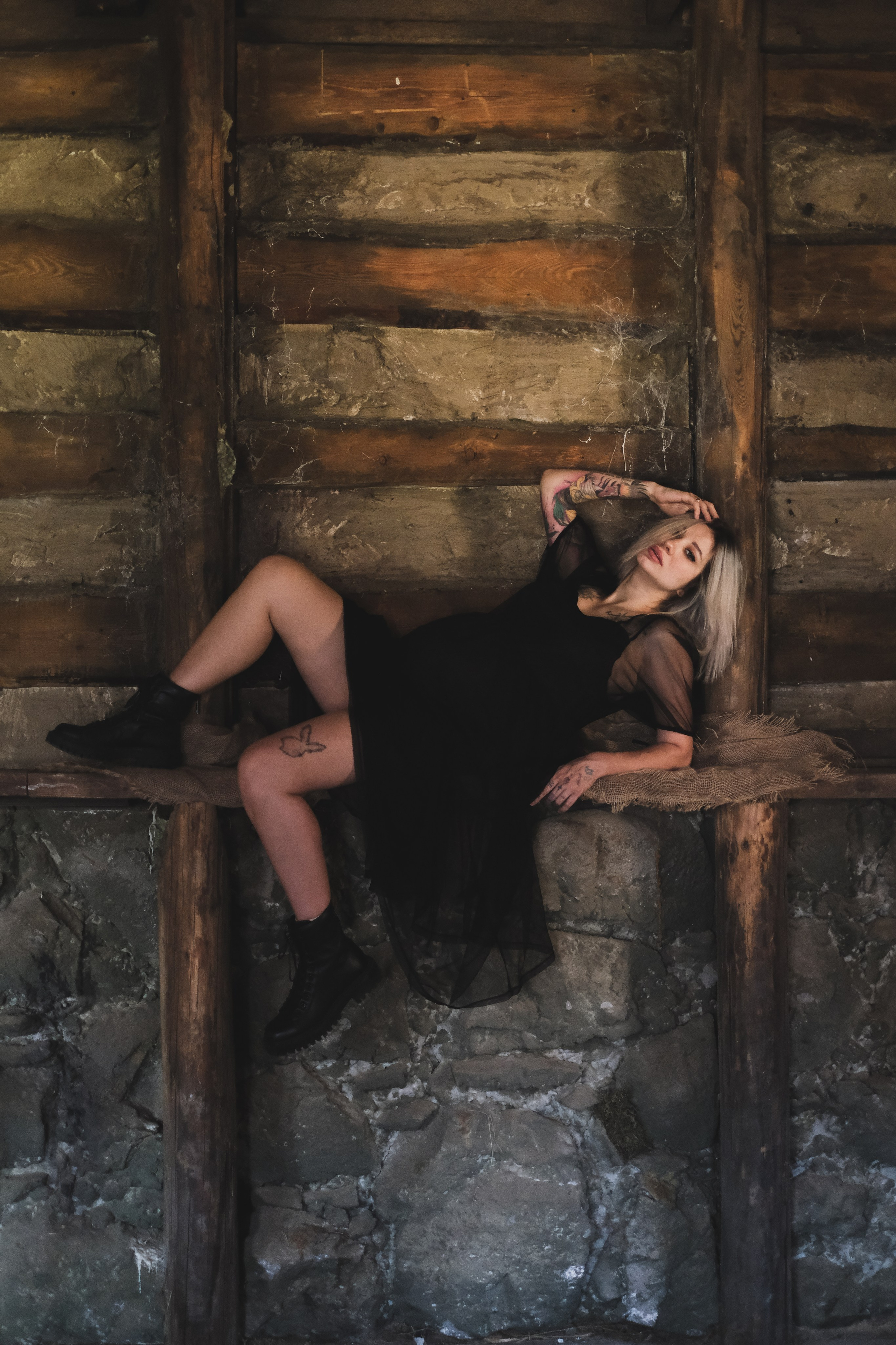 Беременная девушка в черном платье в невесомости в старом доме