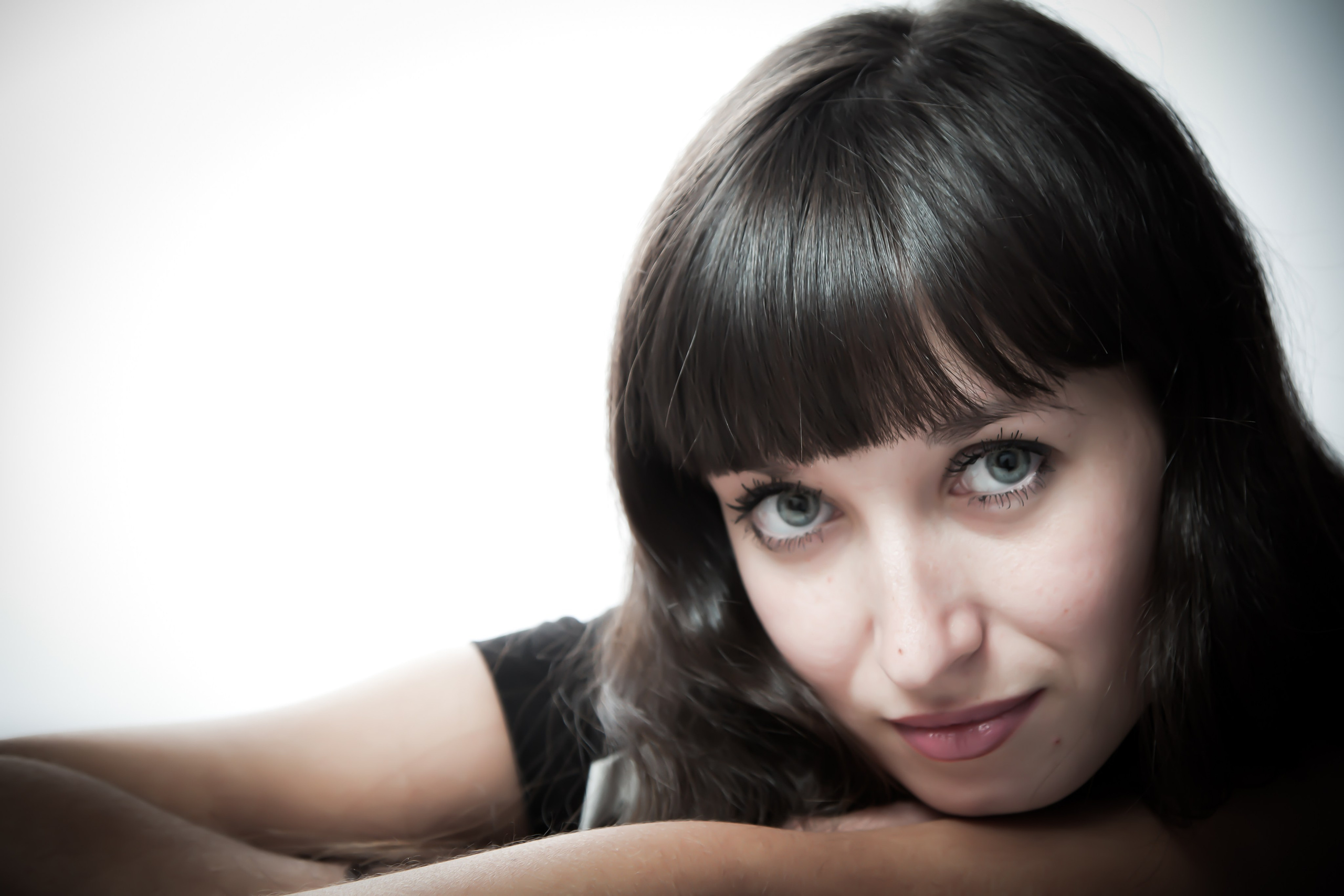 индивидуальная фотосьемка где девушка положив голову на руки смотрит в камеру студийная съемка