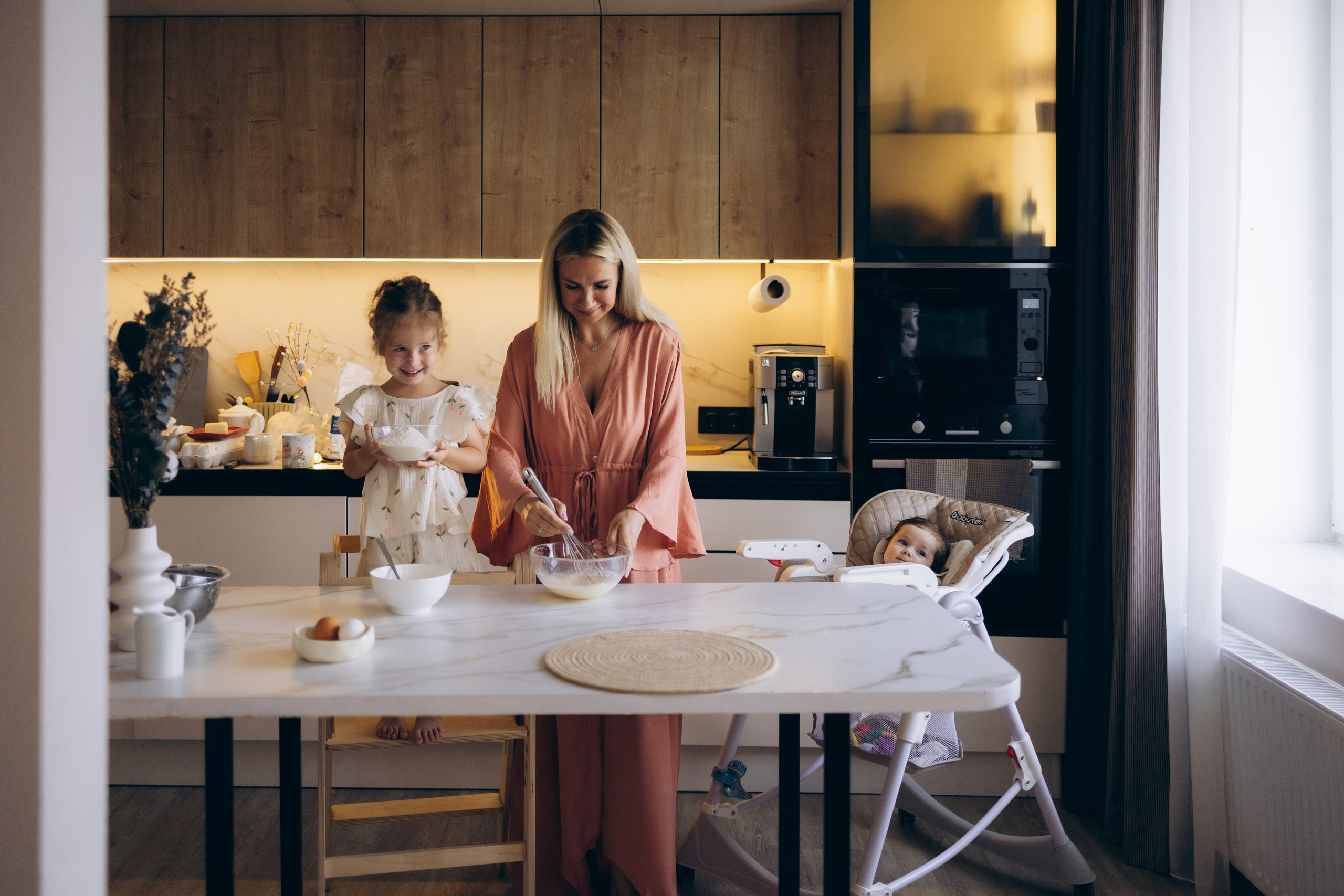 Мама и дочка вместе насыпают муку в миску, излучая улыбки и тепло
