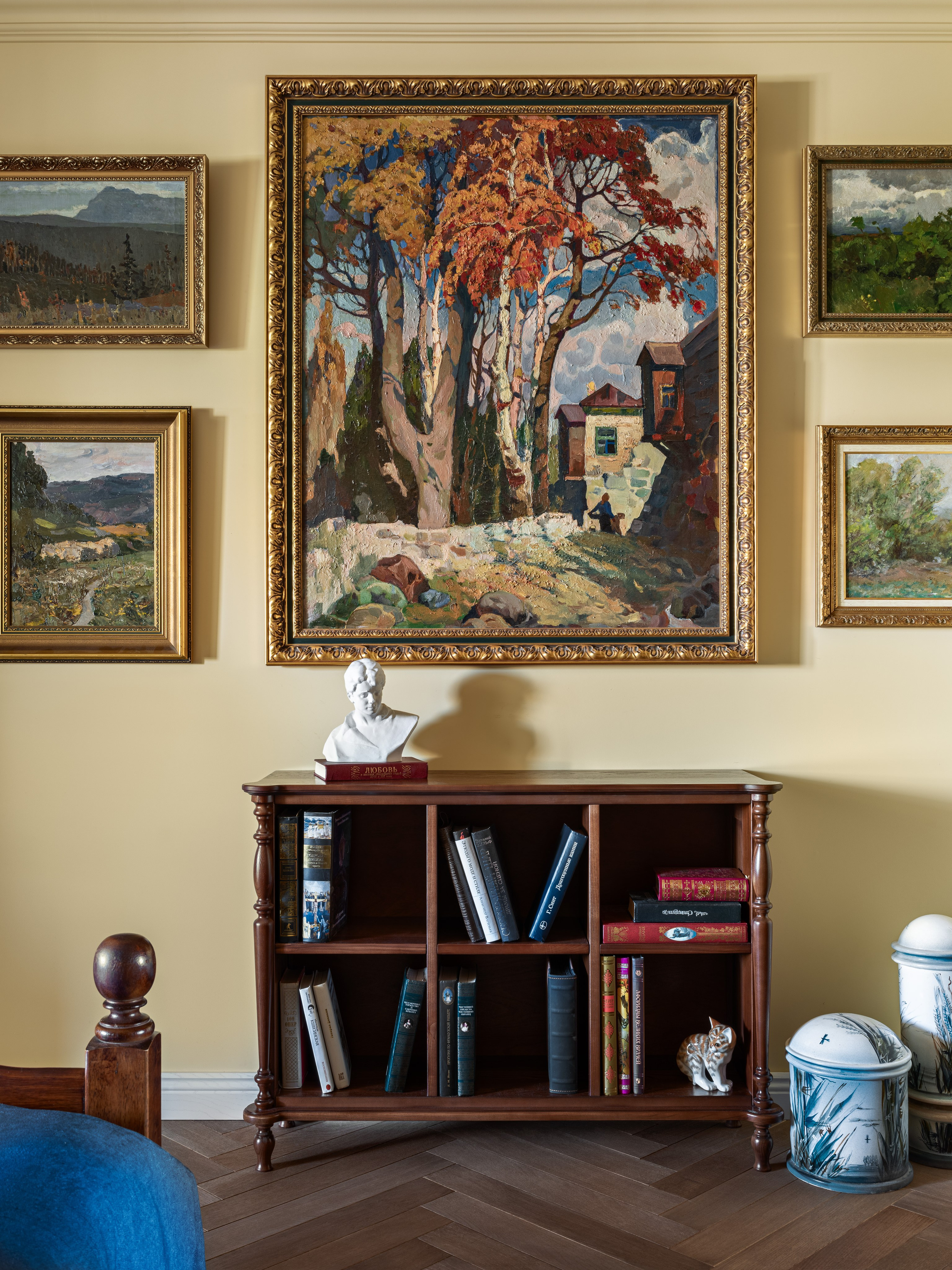 Фото стильного интерьера спальни с картинами, деревянной мебелью и синим текстилем, отражающего современный подход к уюту и эстетике; проект Юлии Капункиной и Альбины Терещенко, стилистика Алины Нелень, фотограф Сергей Денисенко.