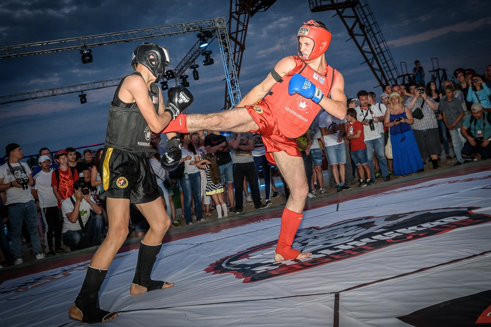 Спортсмен в красном костюме наносит удар ногой