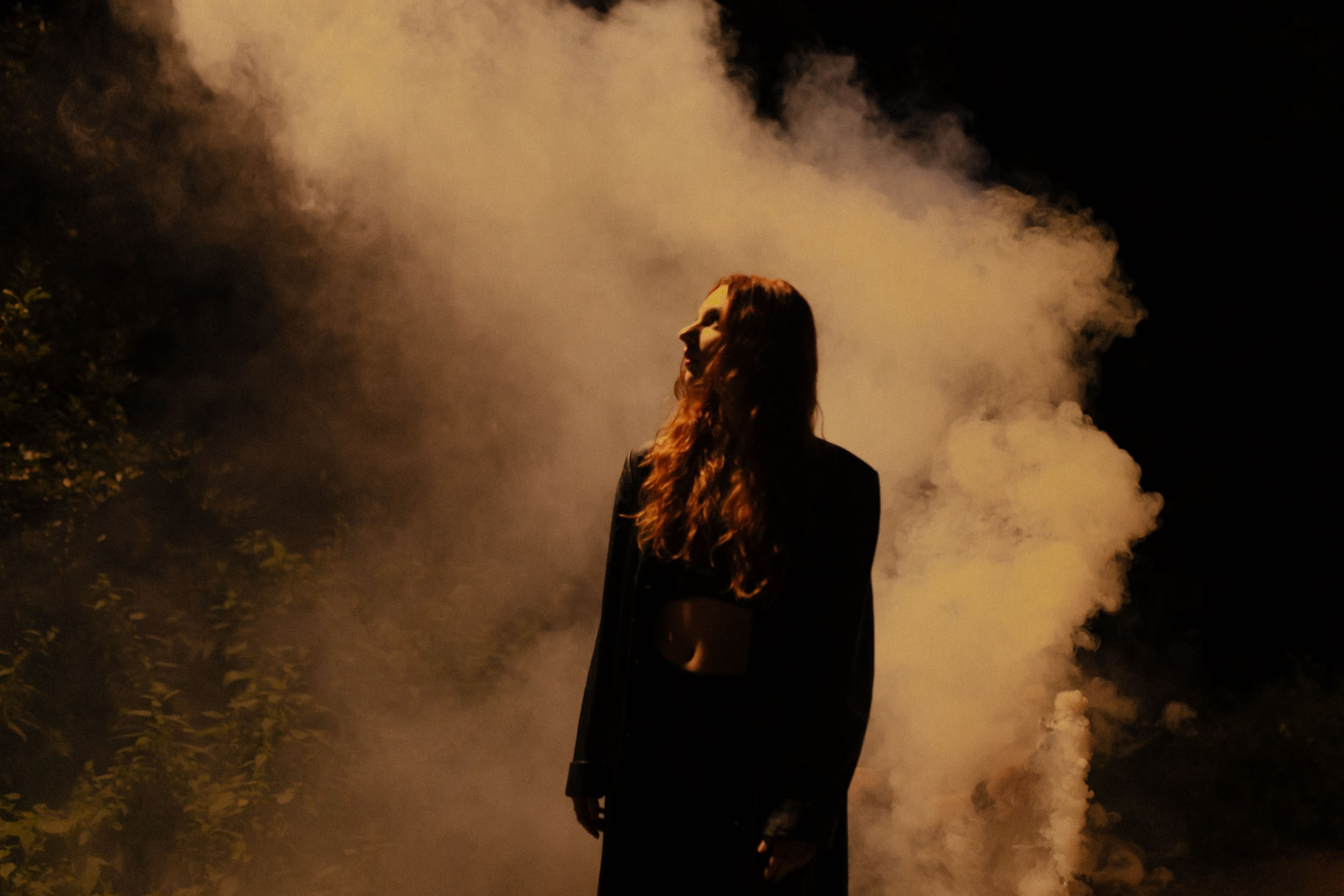 Темный женский силуэт на фоне дыма