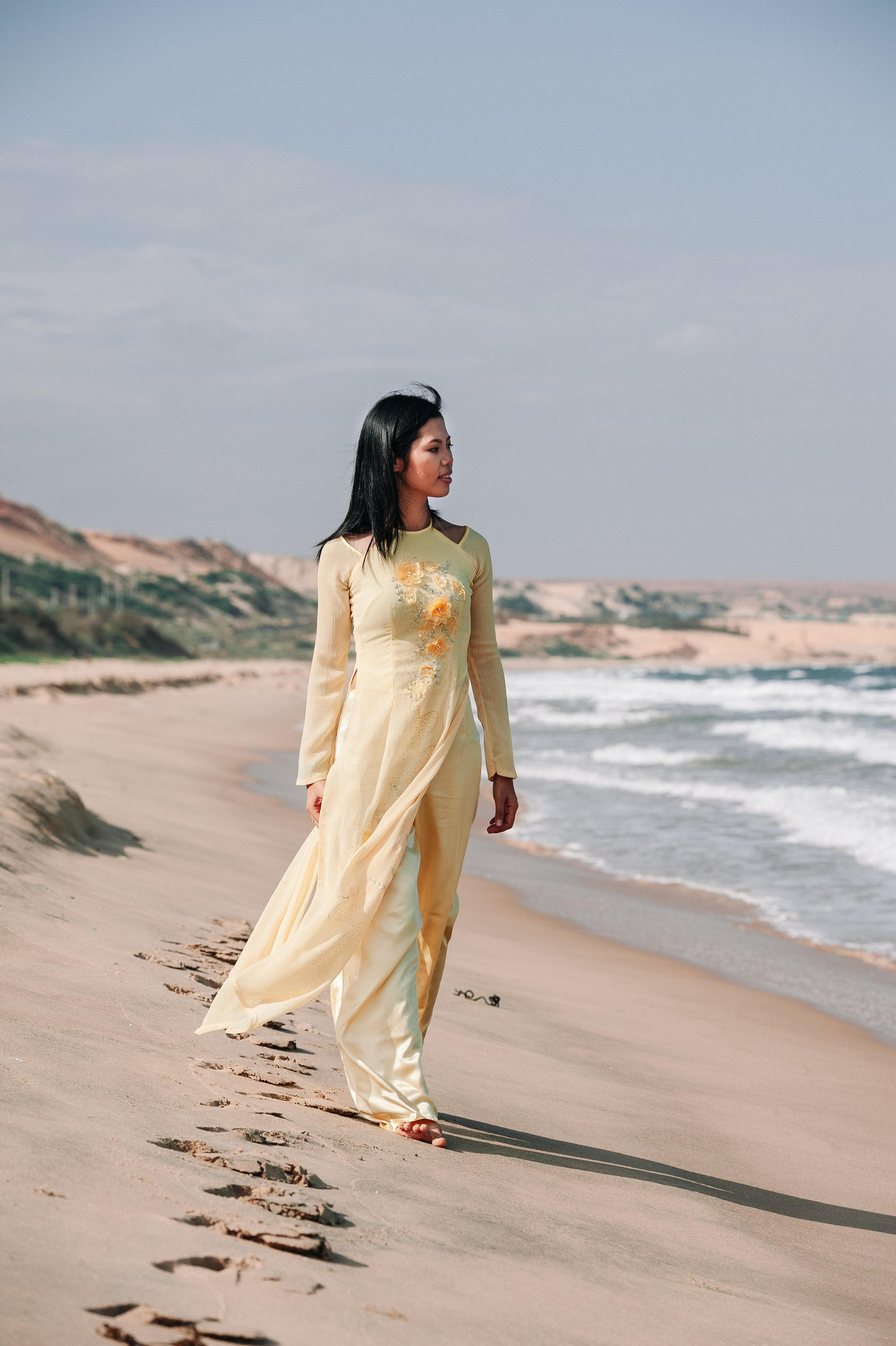 Фотосессия вьетнамской девушки в традиционном вьетнамском костюме Аозай золотого цвета, на пляже Муине, Вьетнам 