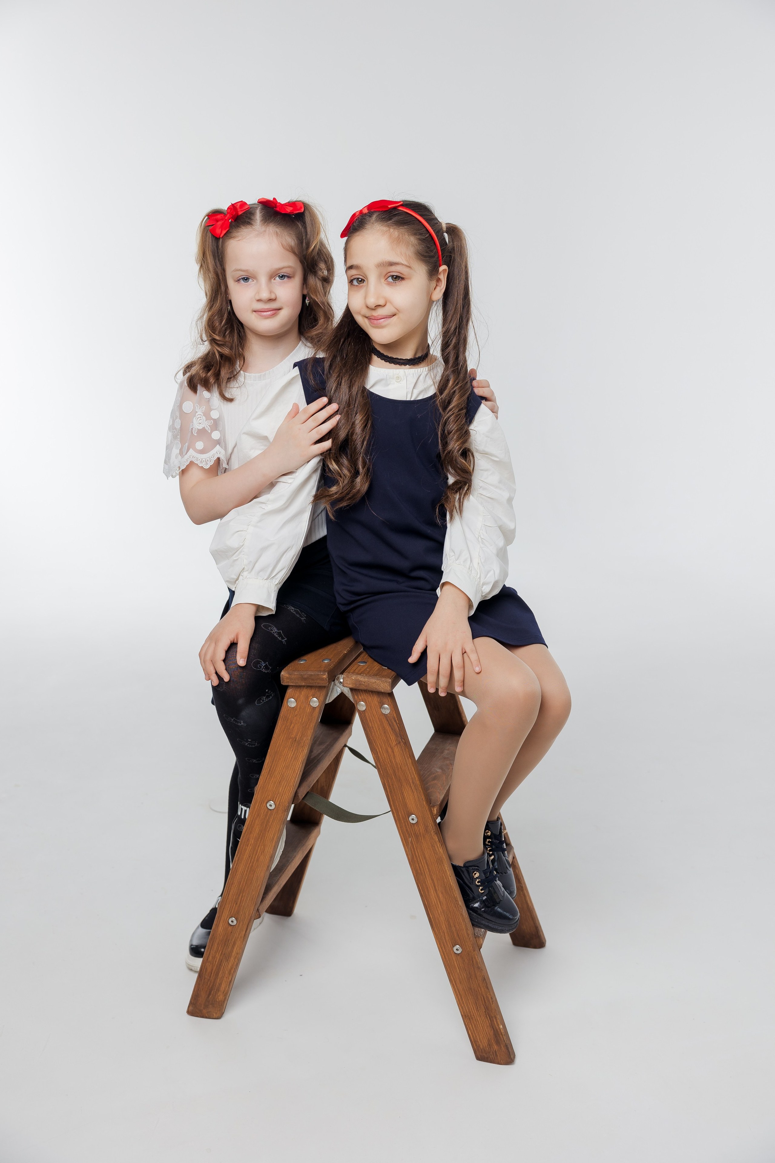 Две девочки сидят на лестнице вместе в студии