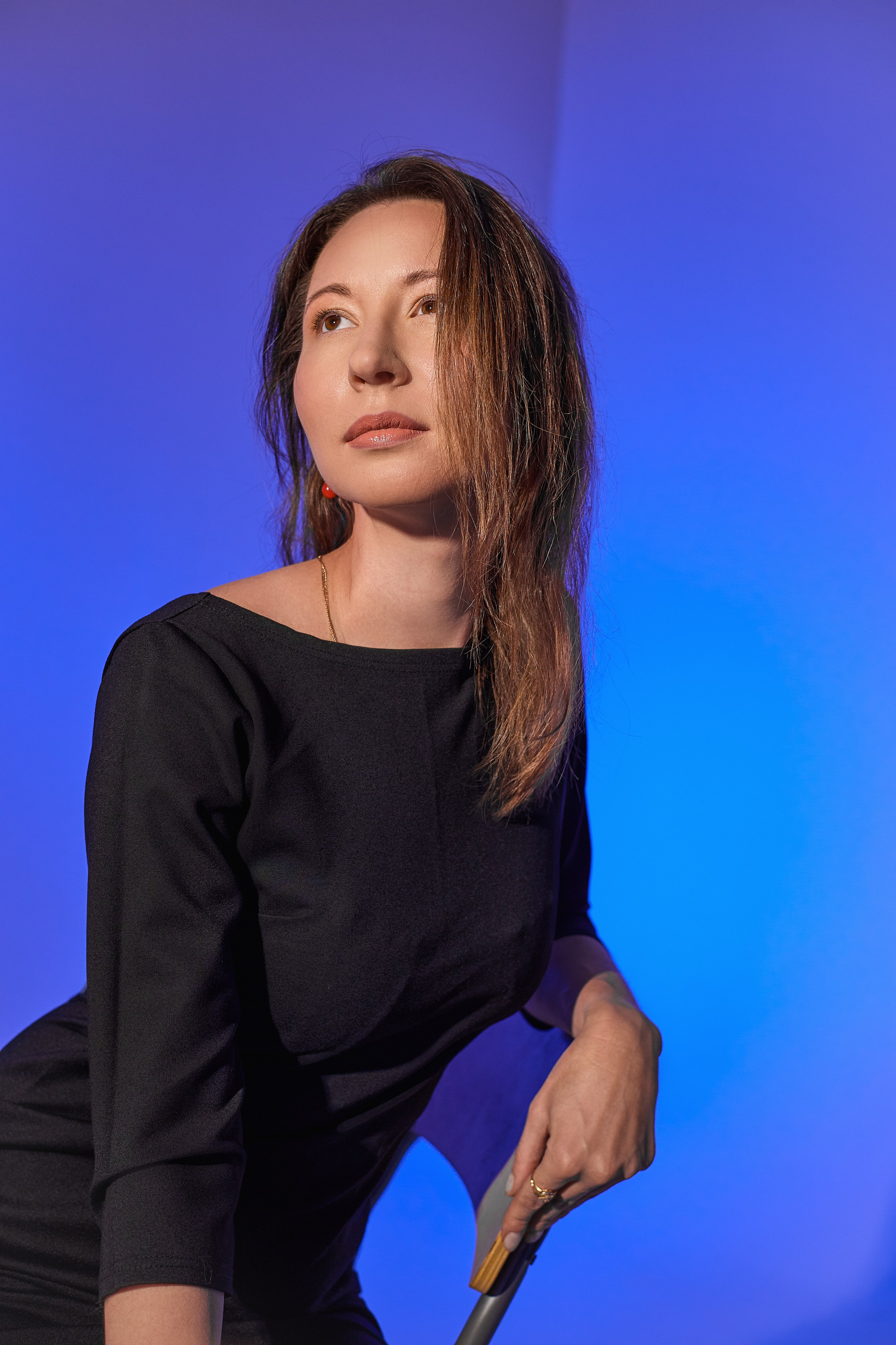 Черное классическое платье выше колена с вырезом на спине и открытыми плечами лодочкой. Лаконичный элегантный силуэт, мягкая чувственность и выразительность без излишней детализации, подходит для портретных, fashion и контент съемок. Подходит для портретных, fashion и контент-съёмок, съёмок в стиле «вечер», «студийный минимализм» или «cinematic».