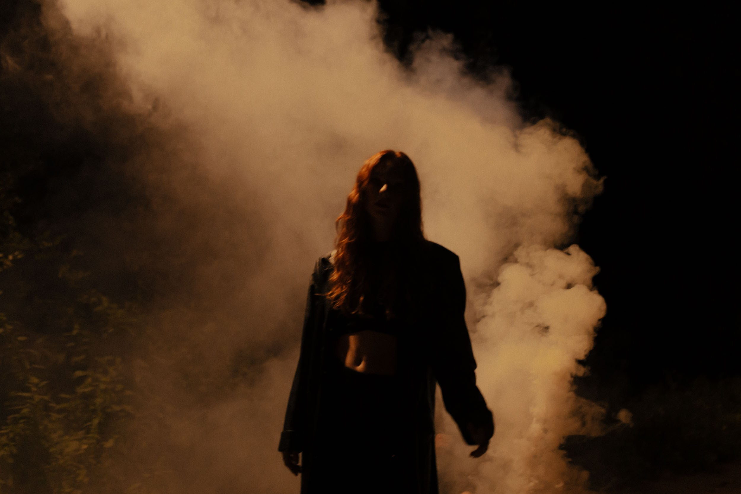 Темный женский силуэт на фоне дыма
