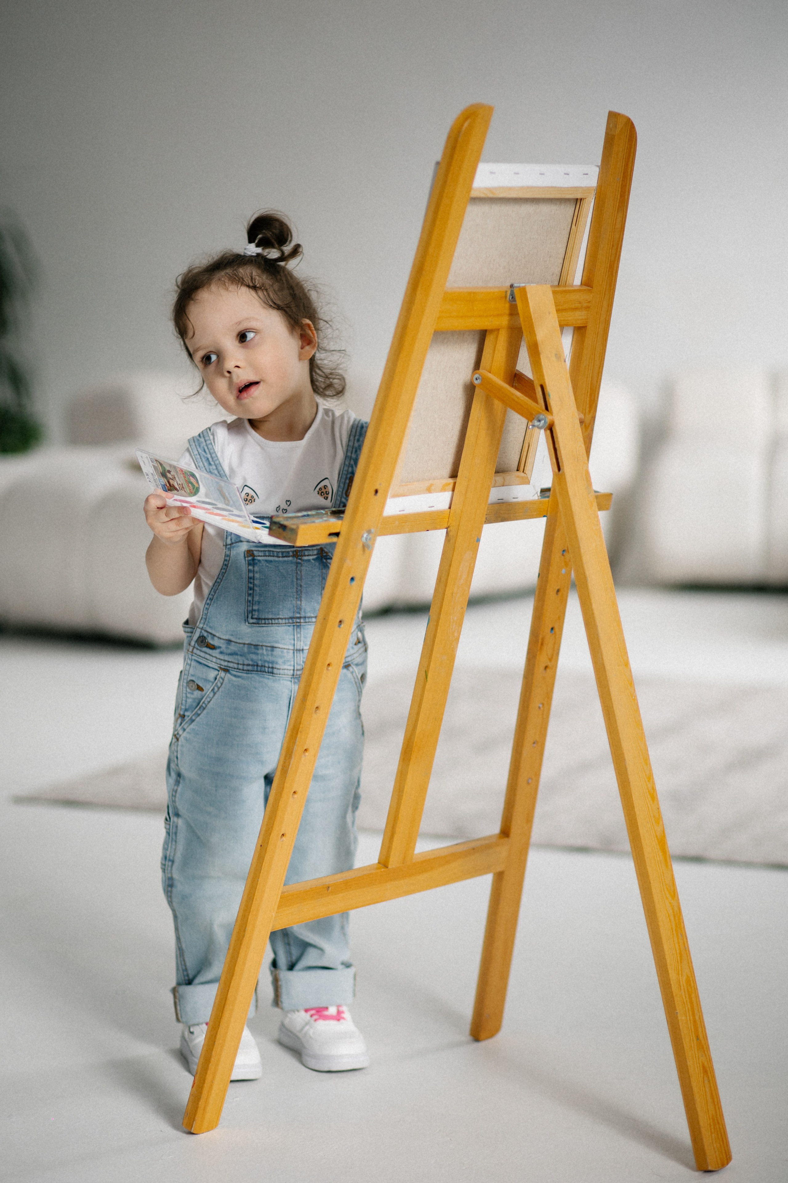 юная художница рисует на мольберте 