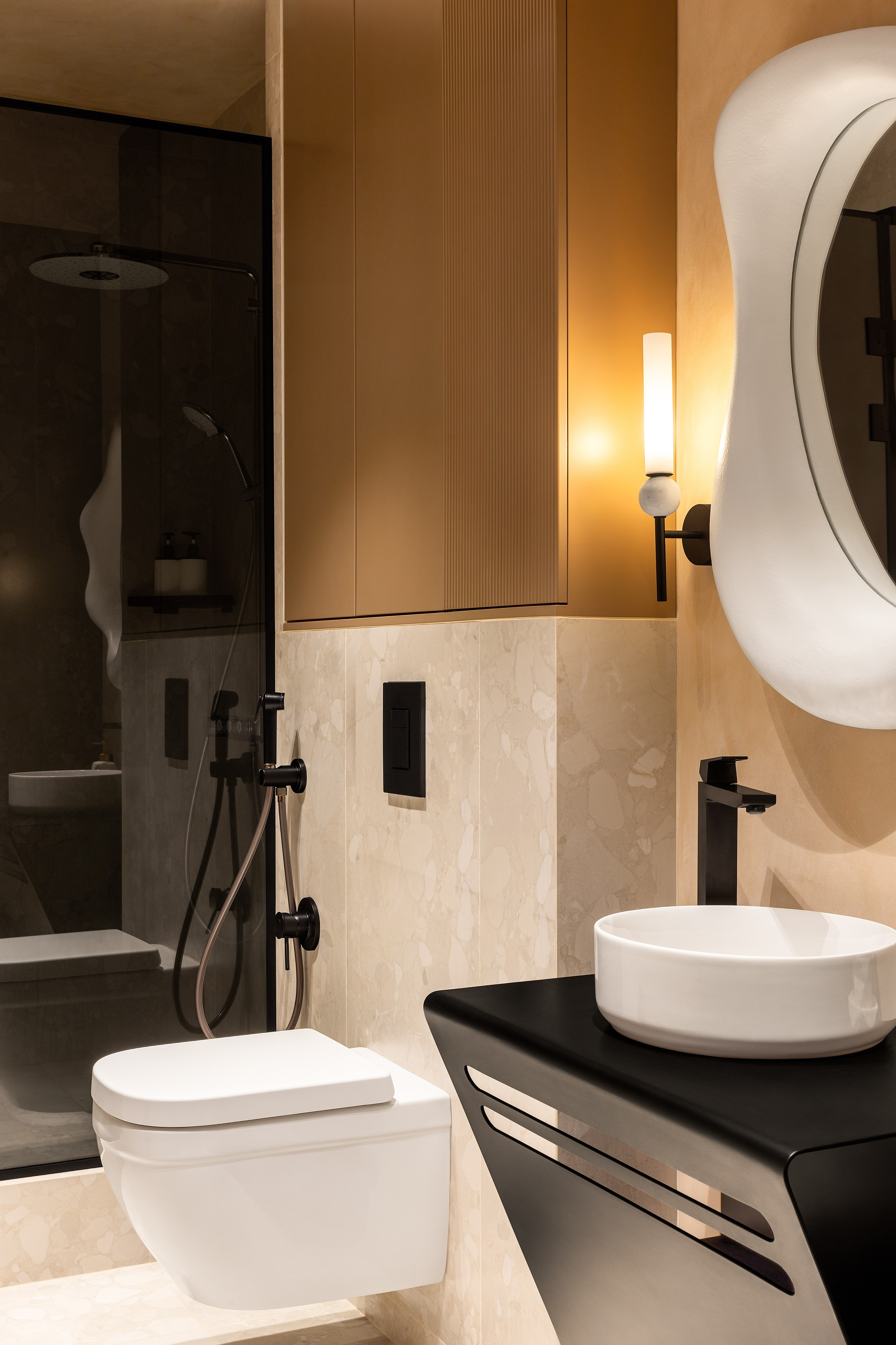 интерьер гостевого санузела в современном стиле в теплой  цветовой гамме с интересным зеркалом 