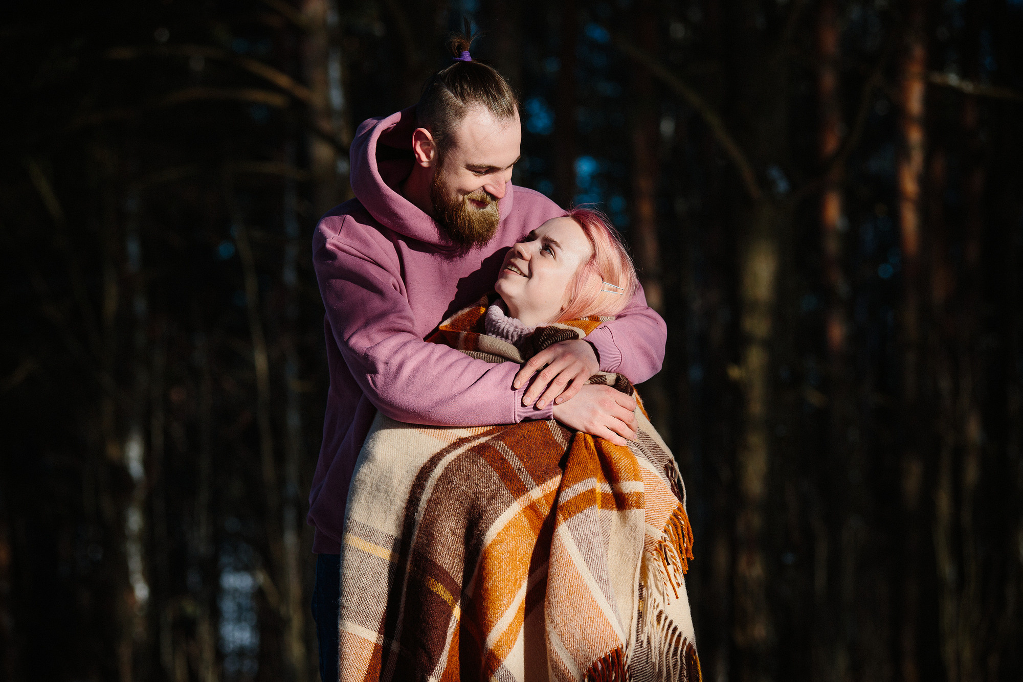 Он и она в пледе на фоне темного леса