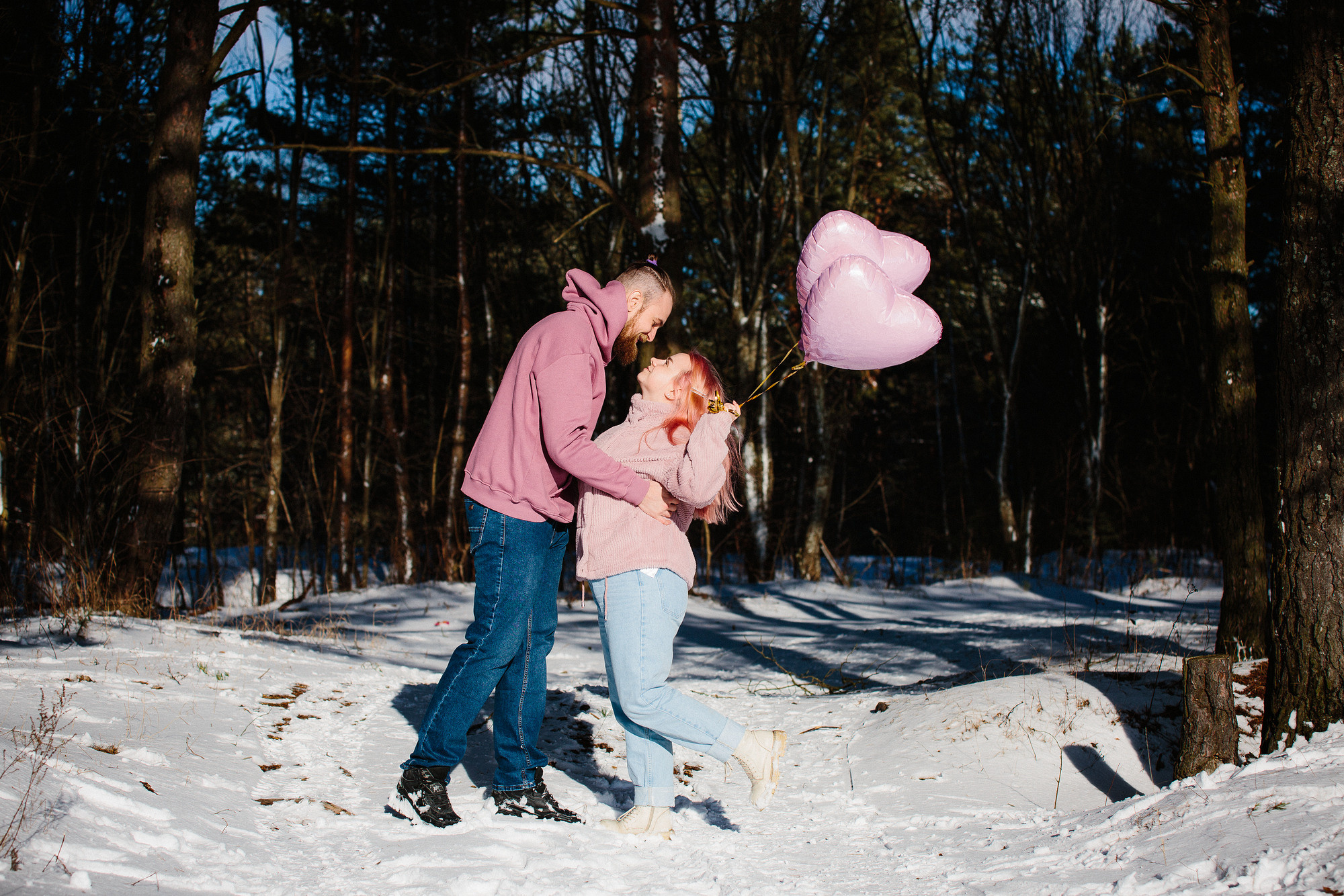 Молодая пара с воздушными шарами в форме сердец