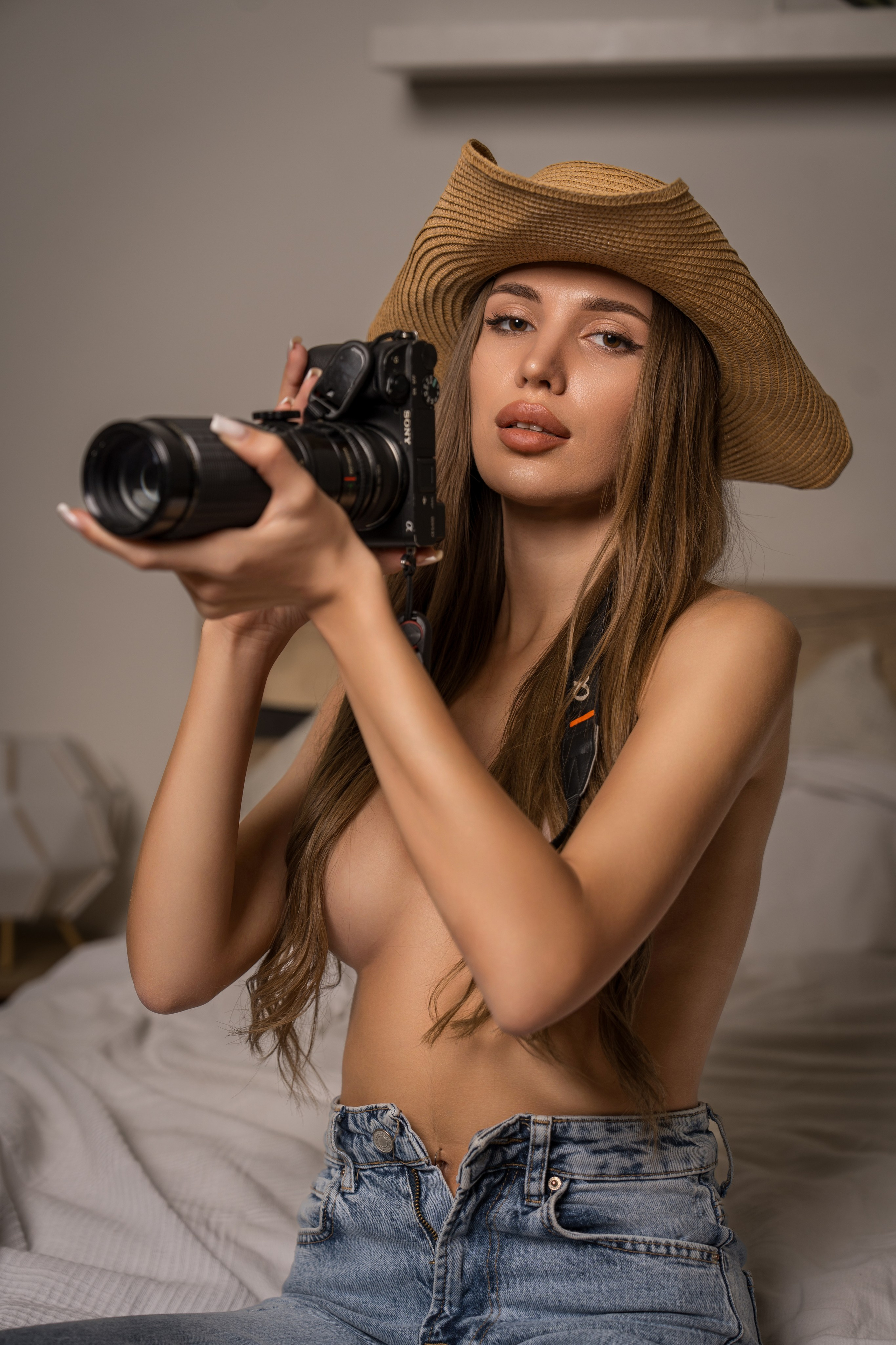 смелая фотосессия в джинсах и шляпке с фотоаппаратом 