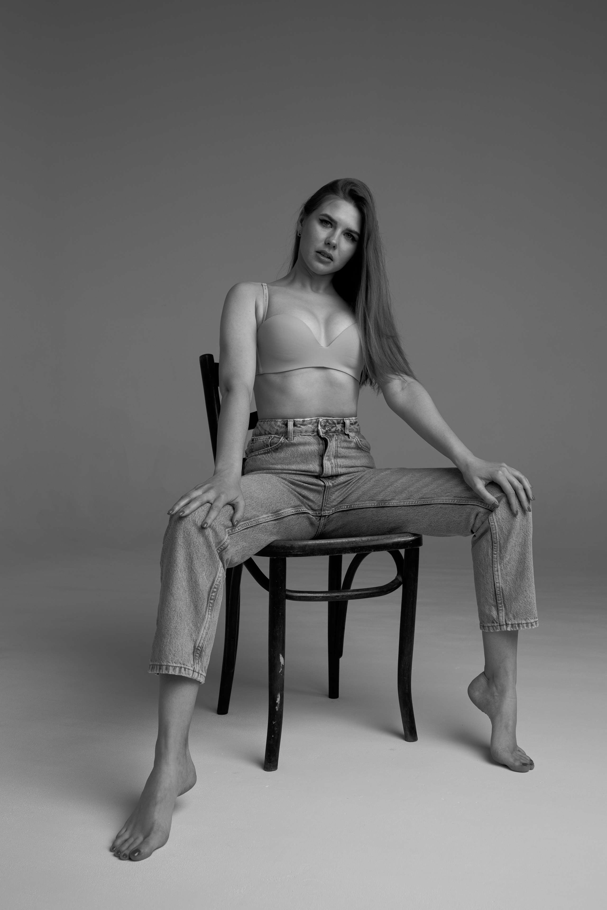 девушка сидит на стуле с расставленными ногами