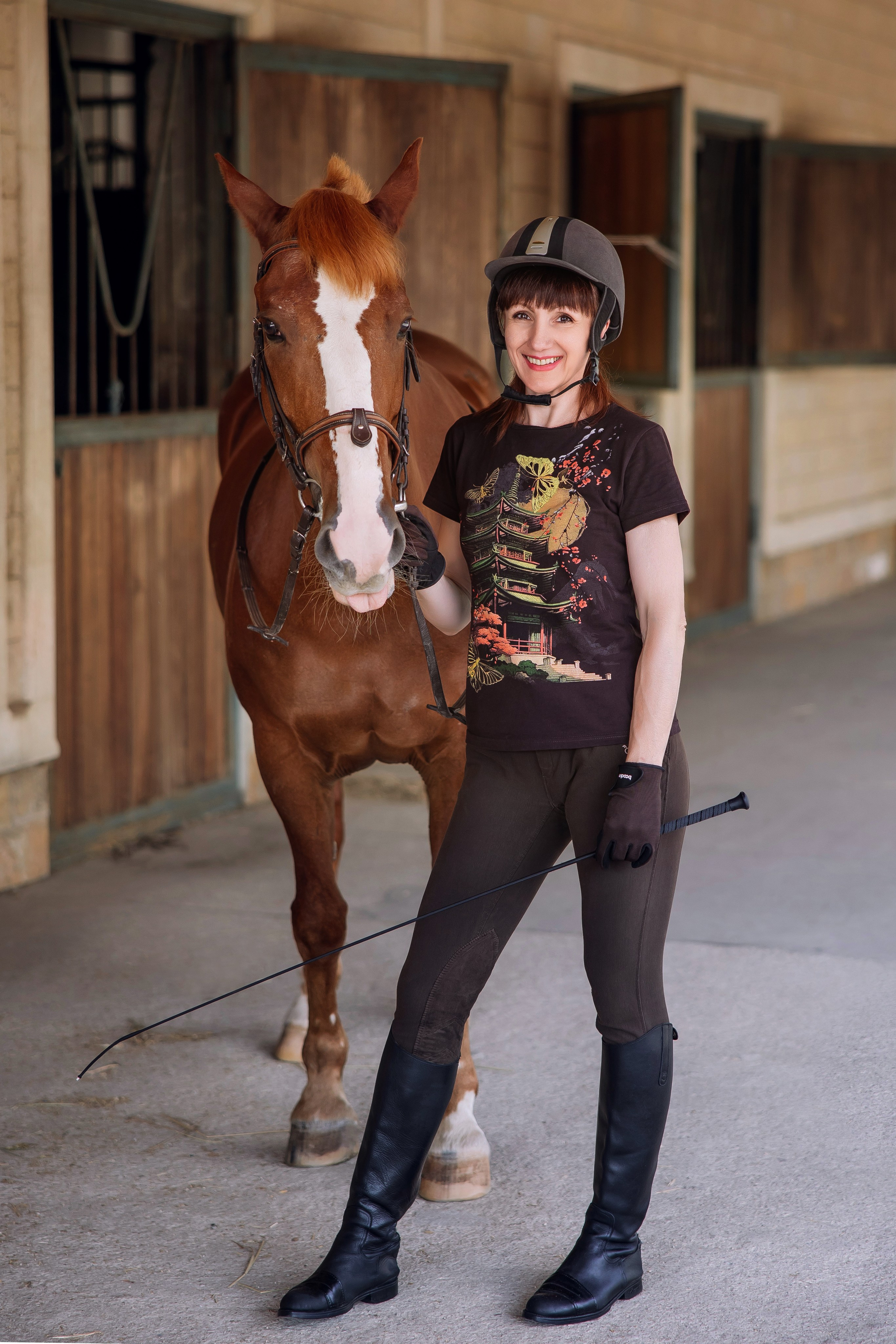 Фотография наездницы с лошадью в конюшне