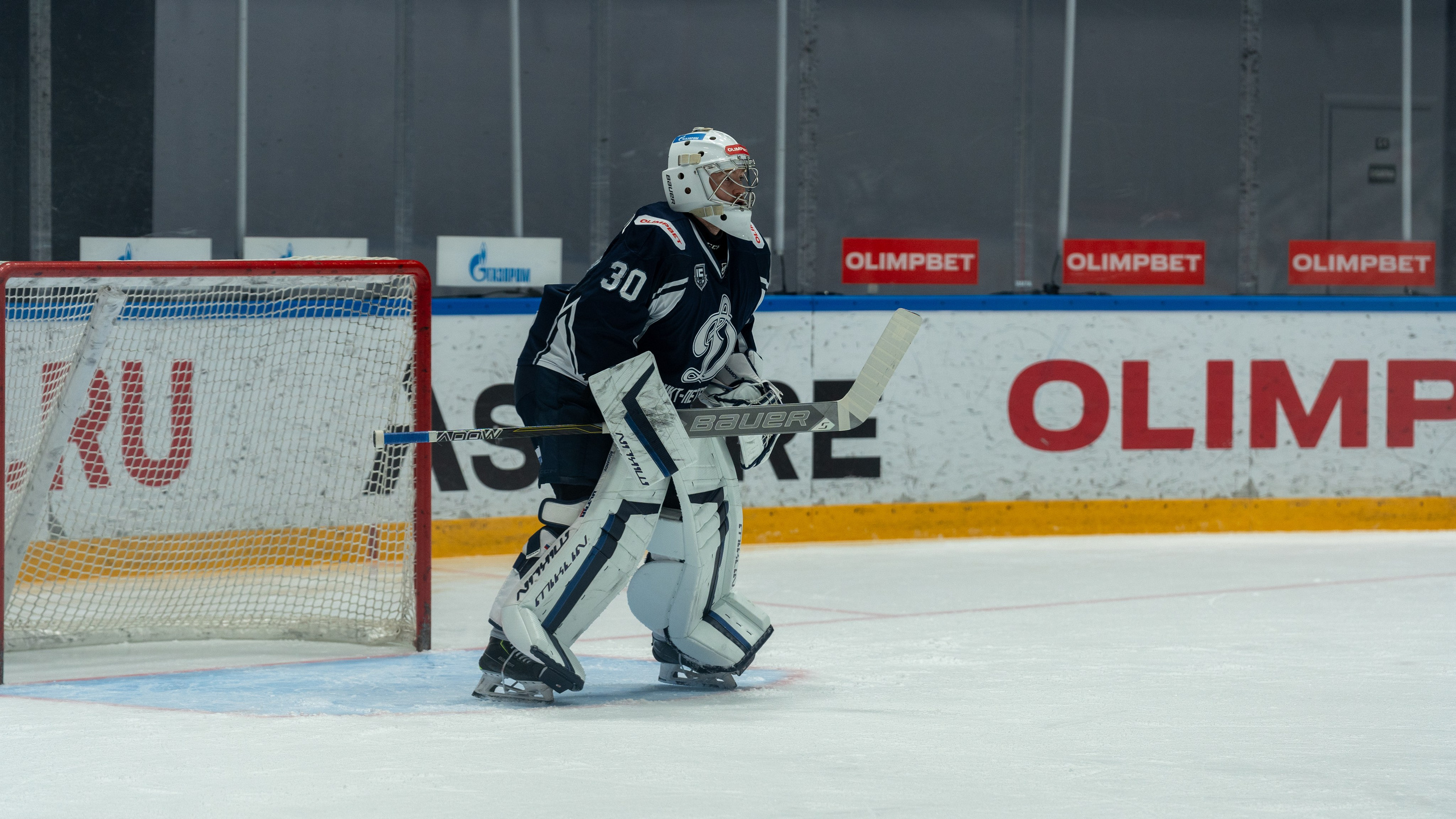 Вратарь ХК «Динамо» (СПб) в напряжённой атаке у ворот. Репортажная спортивная фотосъёмка, Санкт-Петербург.