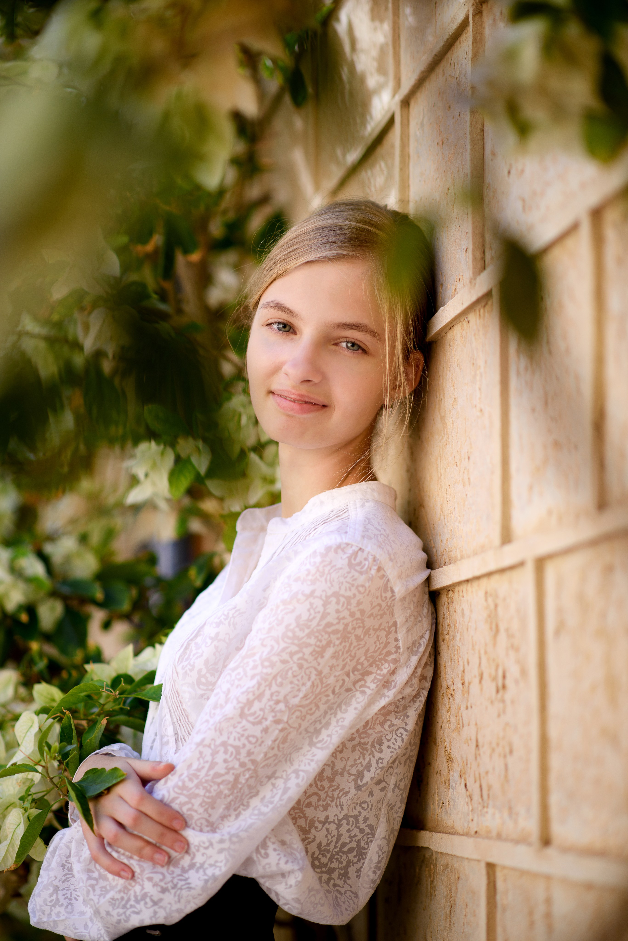 Девочка подросток на фоне старой стены и цветов