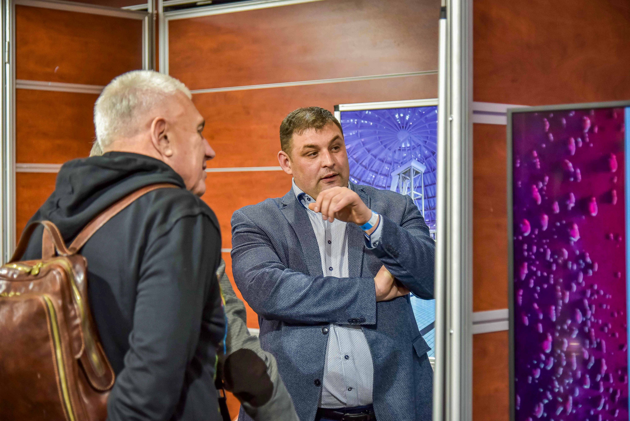 Репортажная съемка с выставки в Москве: снимок передаёт атмосферу общения между представителем компании и посетителями выставки.