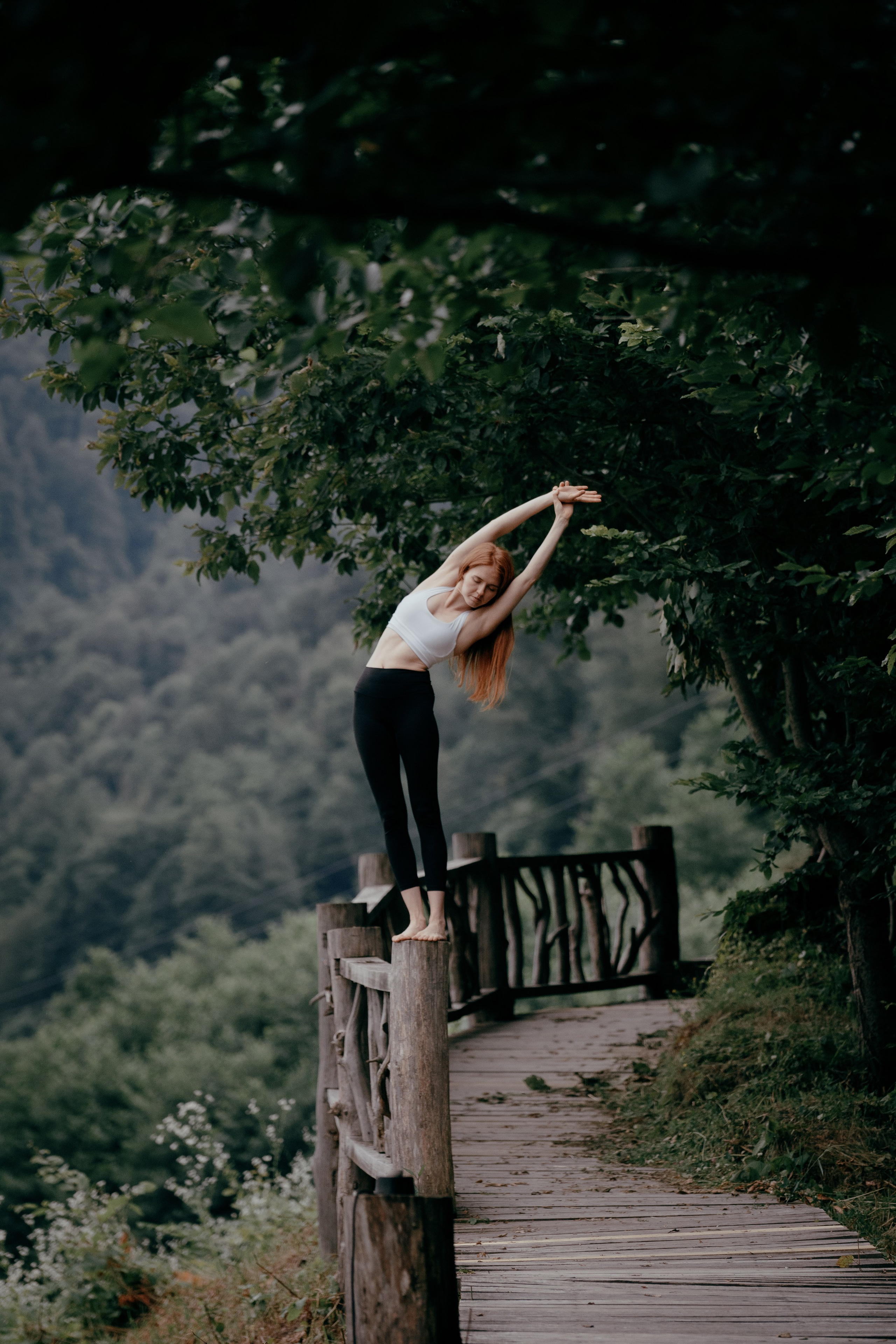 Девушка стоит на стойке на бревне  