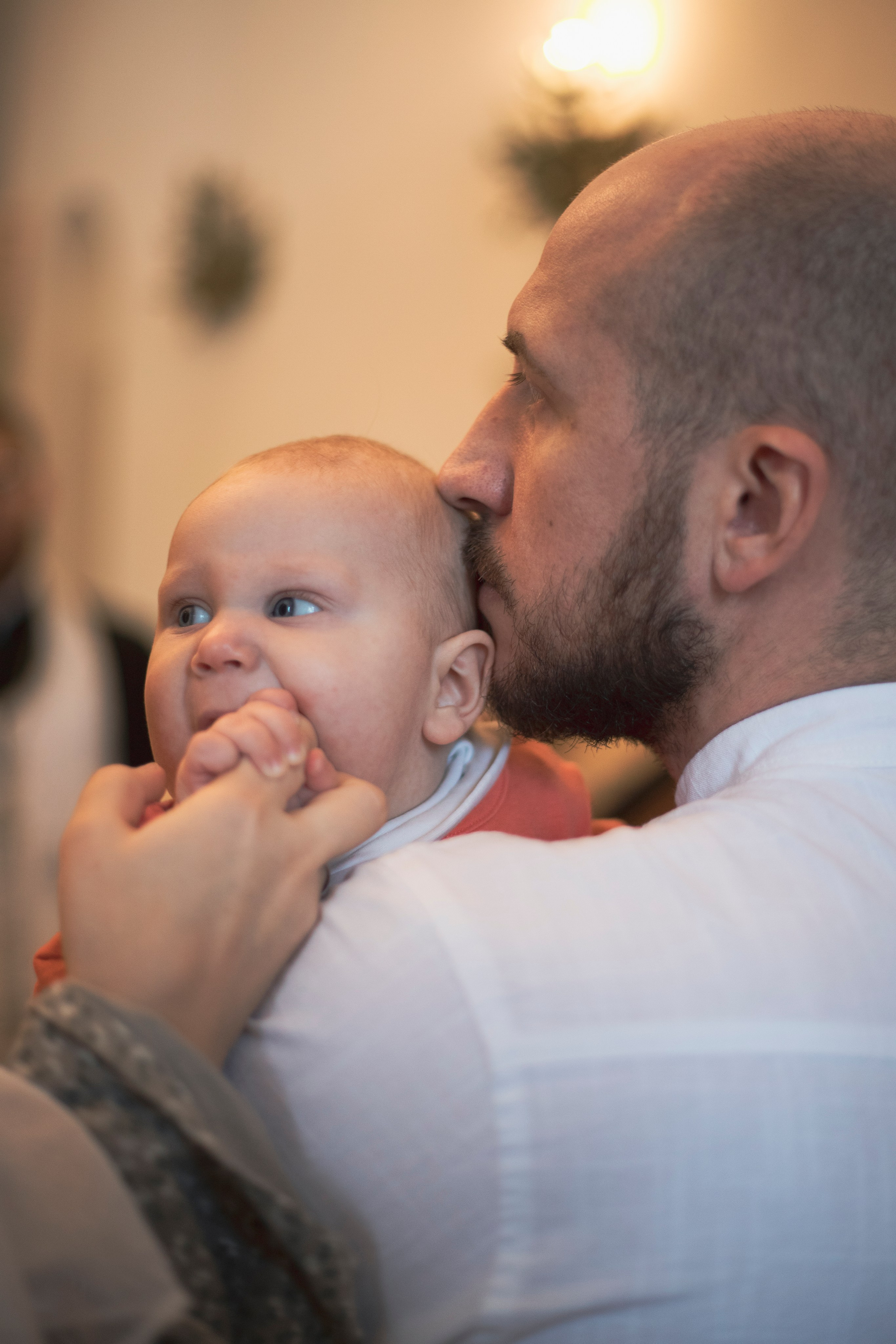 папа целует своего ребенка в макушку