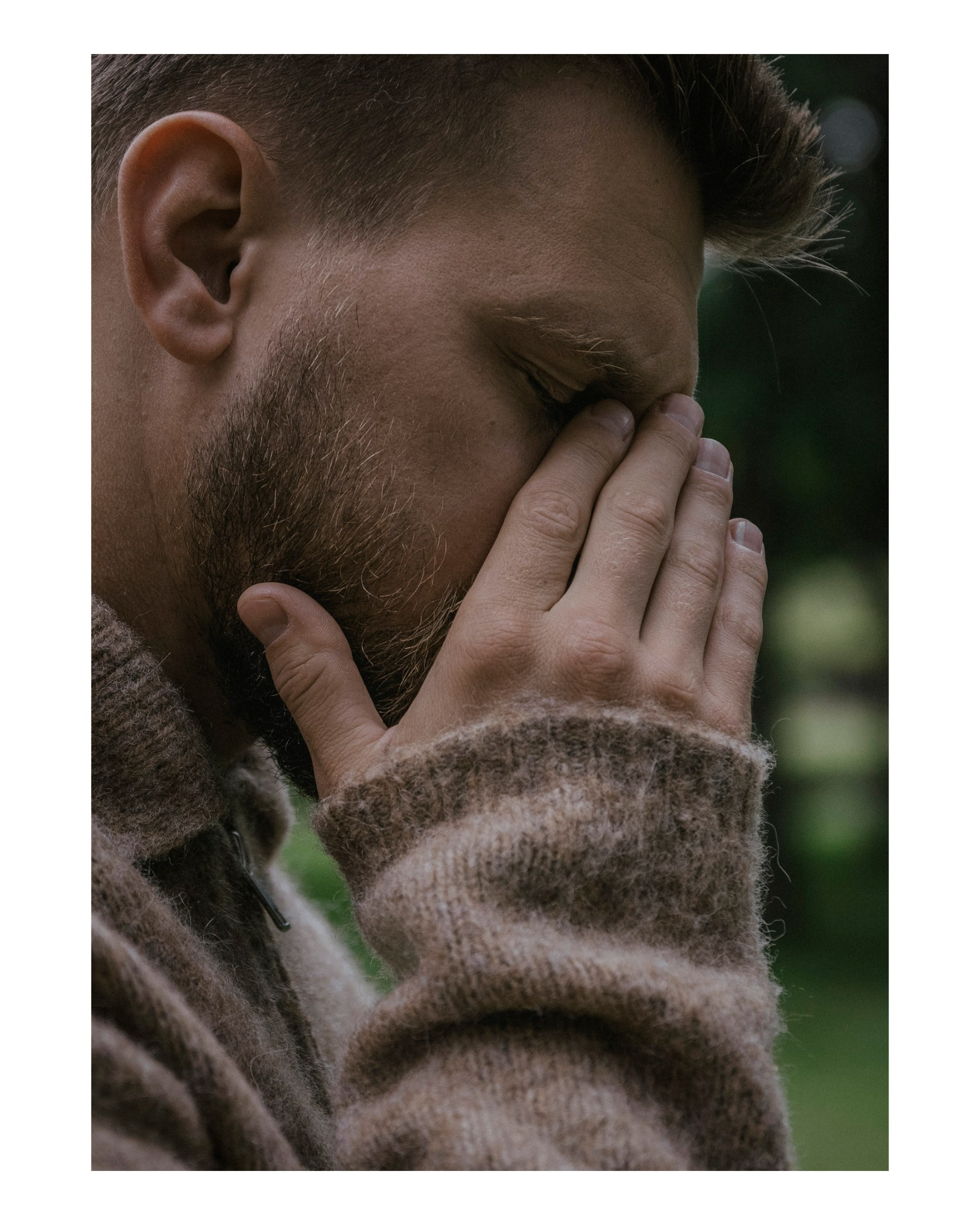 мужчина закрывает лицо рукой