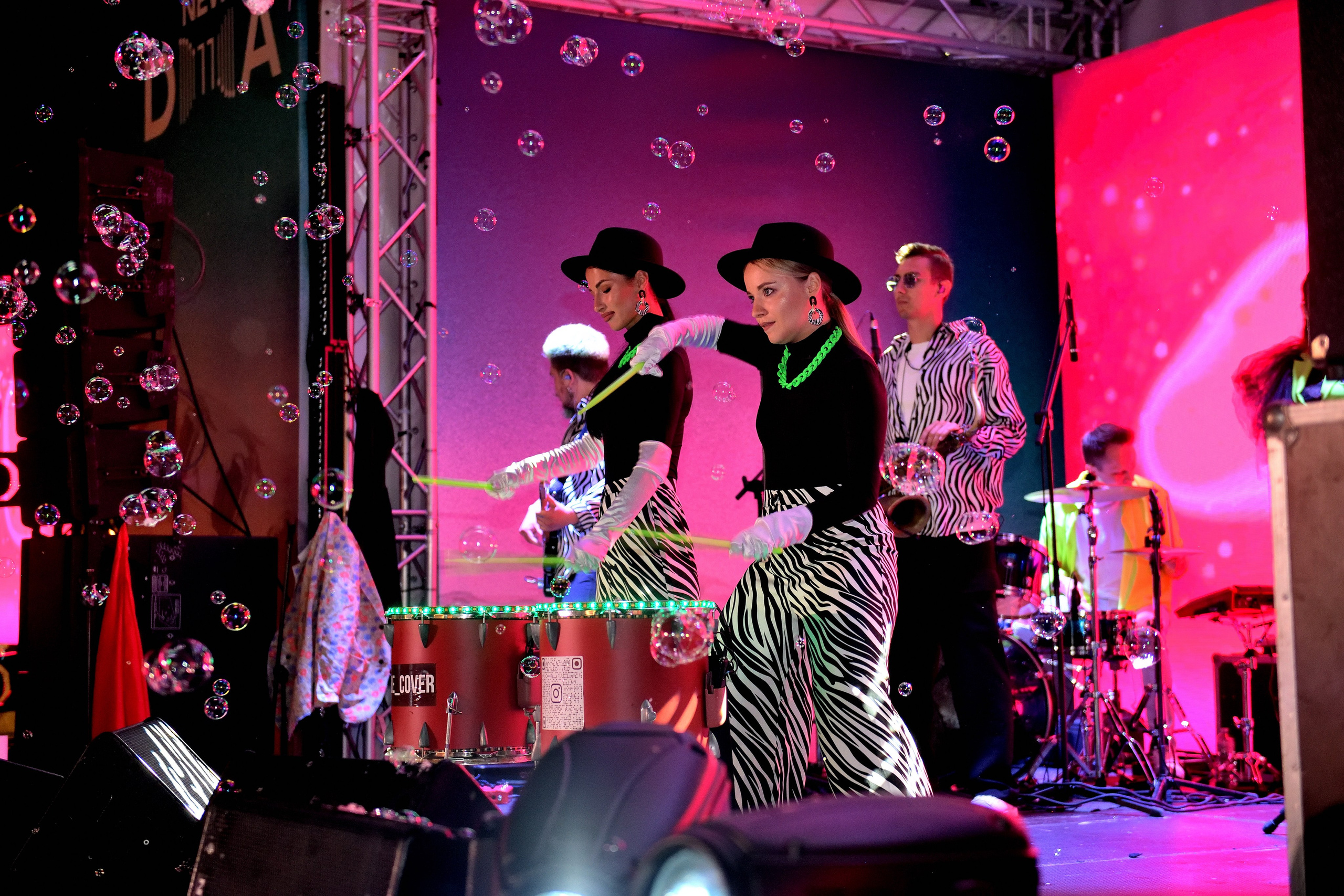 "Группа на подтанцовке играет на барабанах".